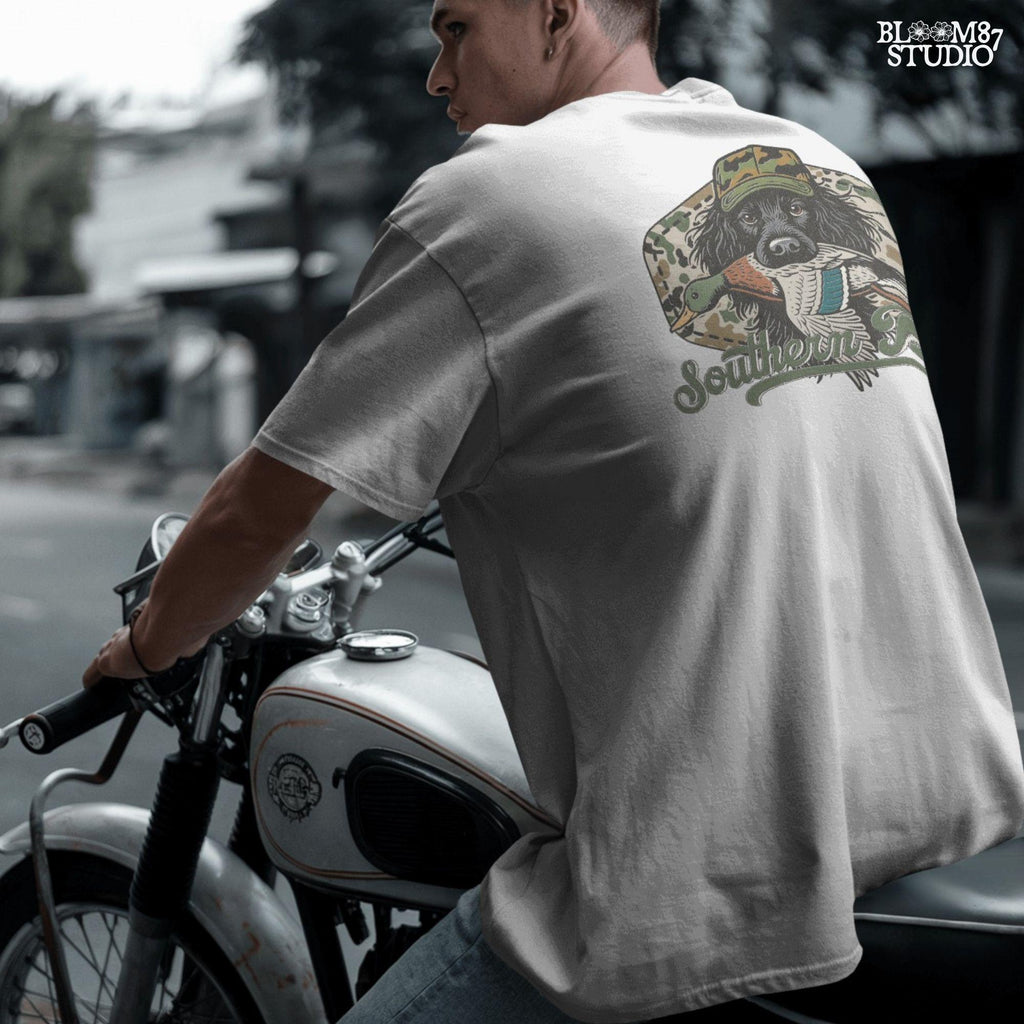 Illustration of a black hunting dog wearing a camo hat, holding a mallard duck in its mouth with the text “Southern Boy” below, in a rustic Southern style.