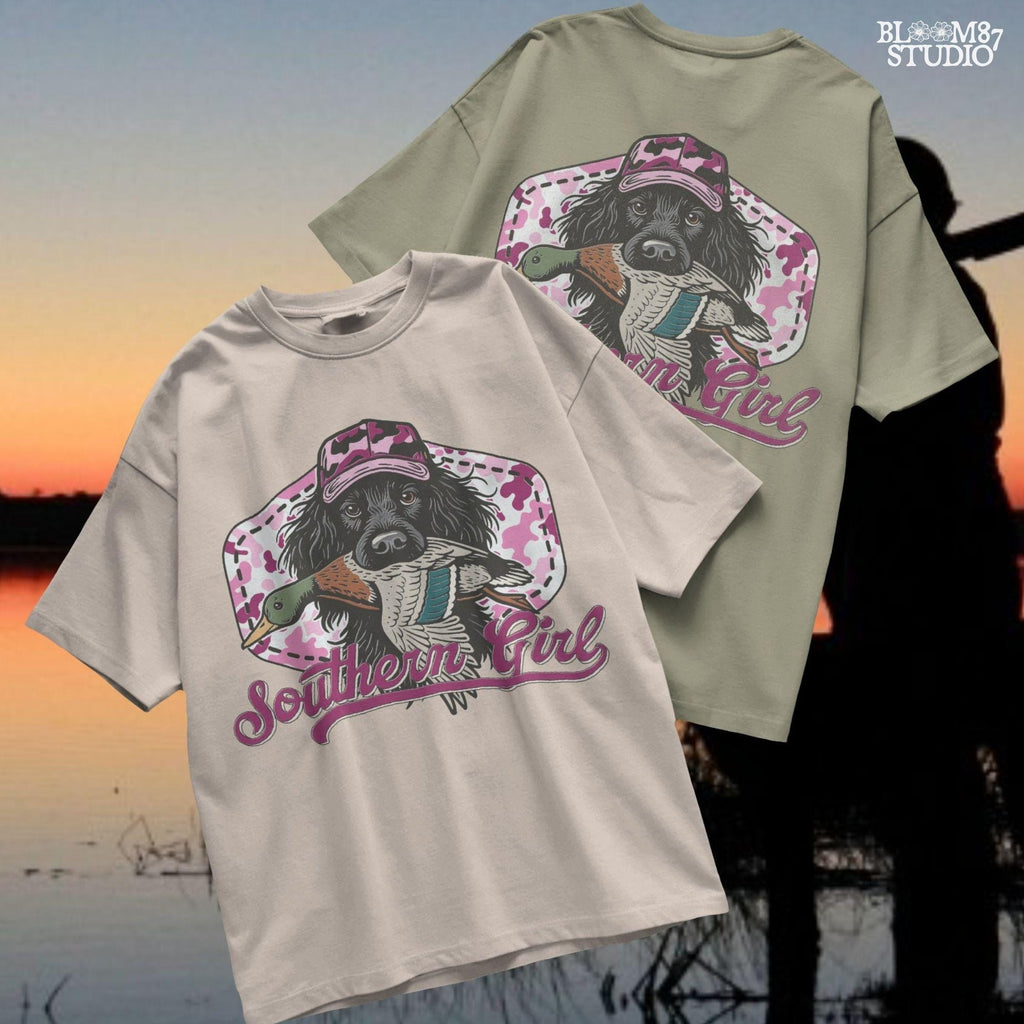 Illustration of a black hunting dog wearing a pink camo hat and holding a mallard duck, with “Southern Girl” text and pink camouflage background.