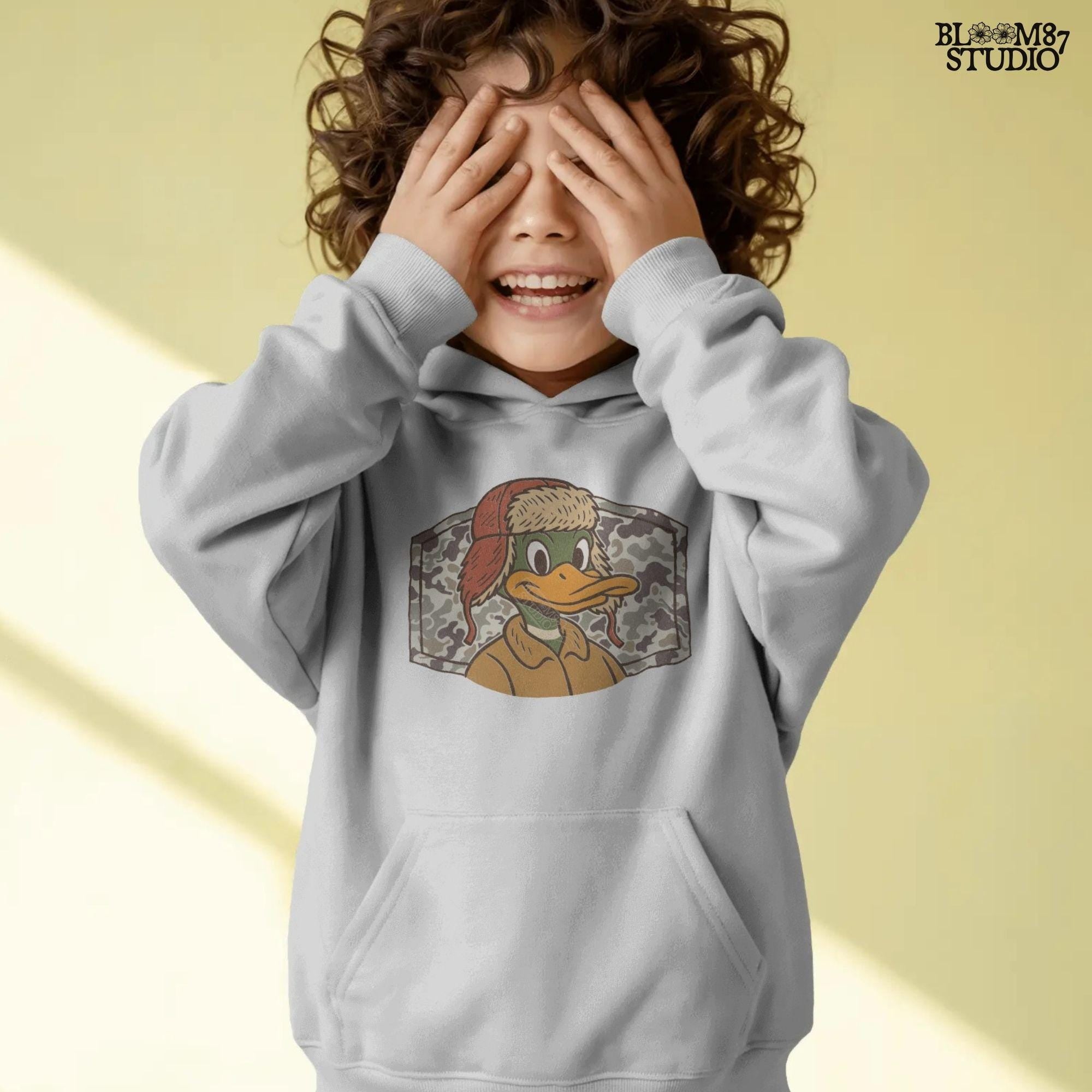 Cartoon duck in a trapper hat and camo jacket, kid-friendly hunting design with autumn theme, suitable for back to school sublimation.