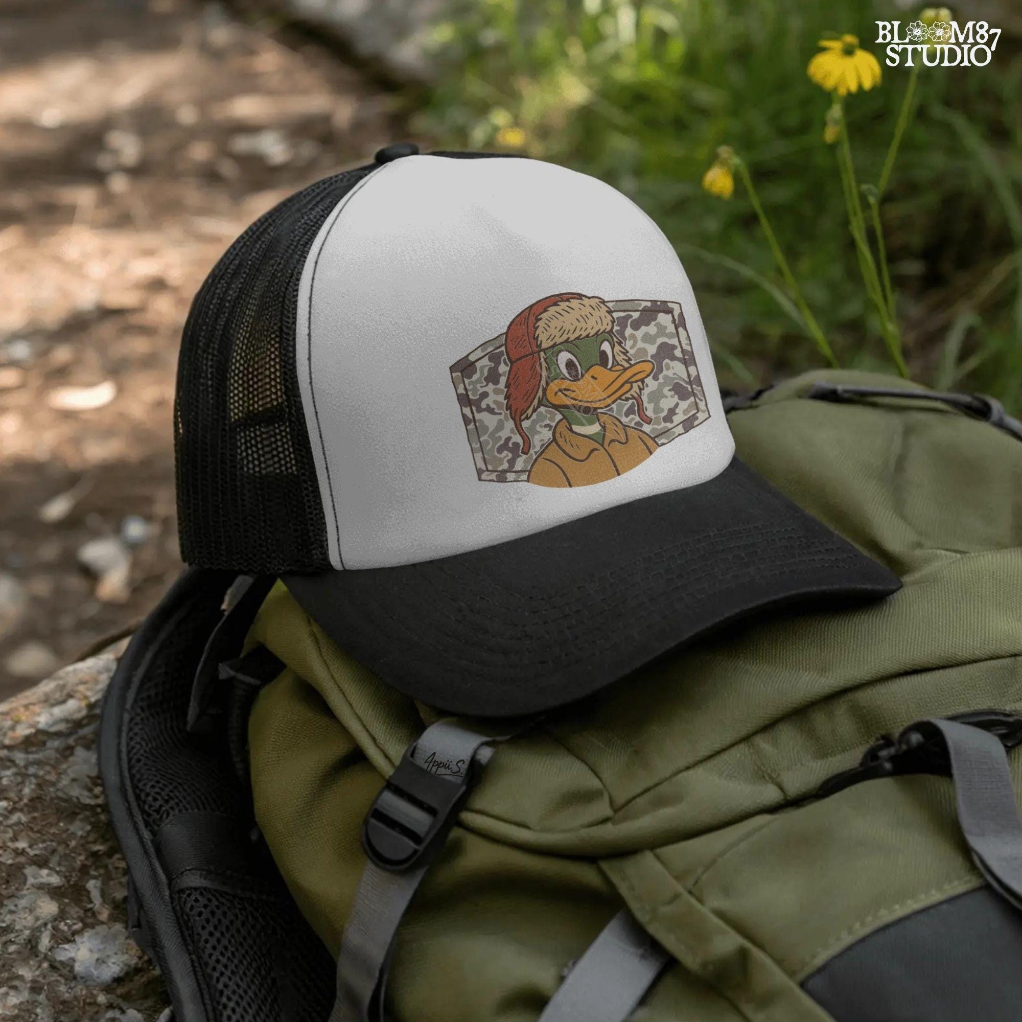 Cartoon duck in a trapper hat and camo jacket, kid-friendly hunting design with autumn theme, suitable for back to school sublimation.