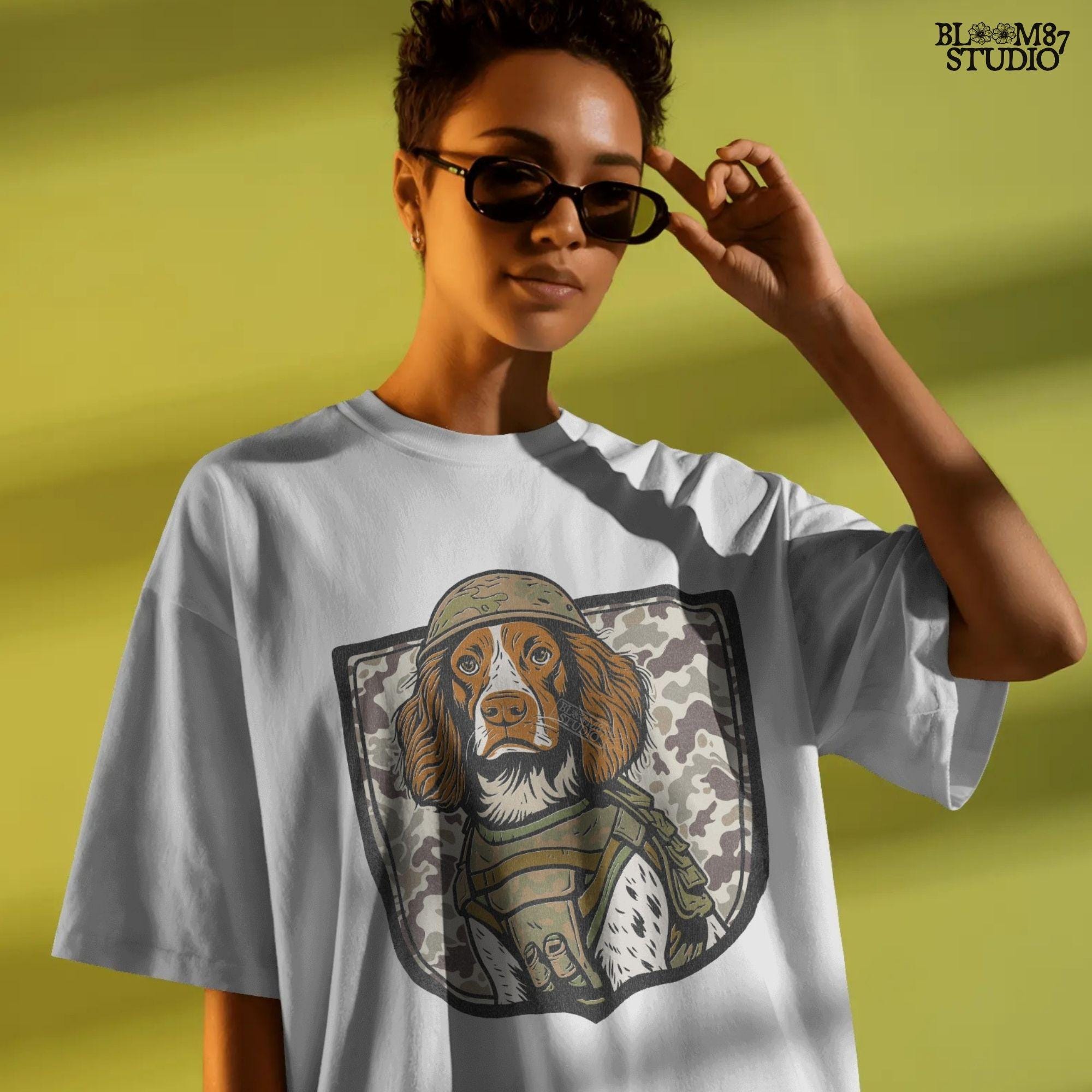 Illustration of a military hunting dog in camo vest and helmet, standing in front of a camouflage shield background, PNG for sublimation use