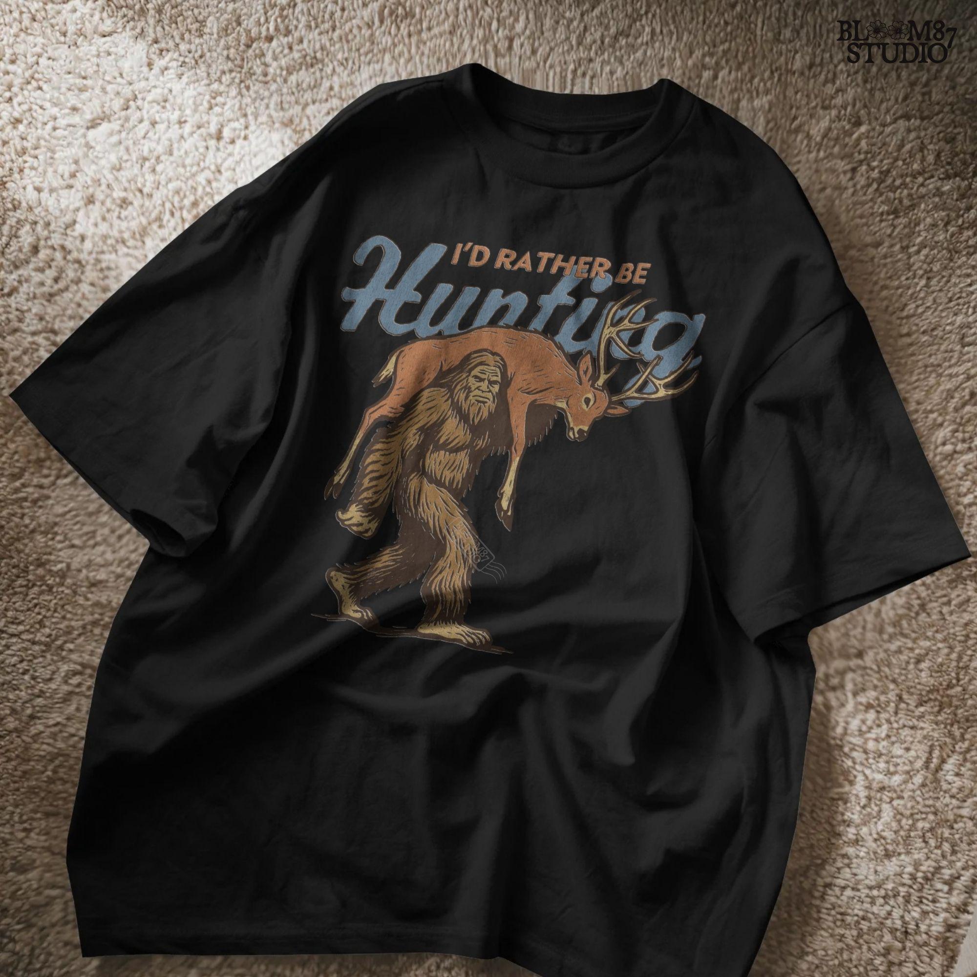 Illustration of Bigfoot carrying a deer on shoulders with text “I’d Rather Be Hunting,” designed for funny rustic sublimation projects