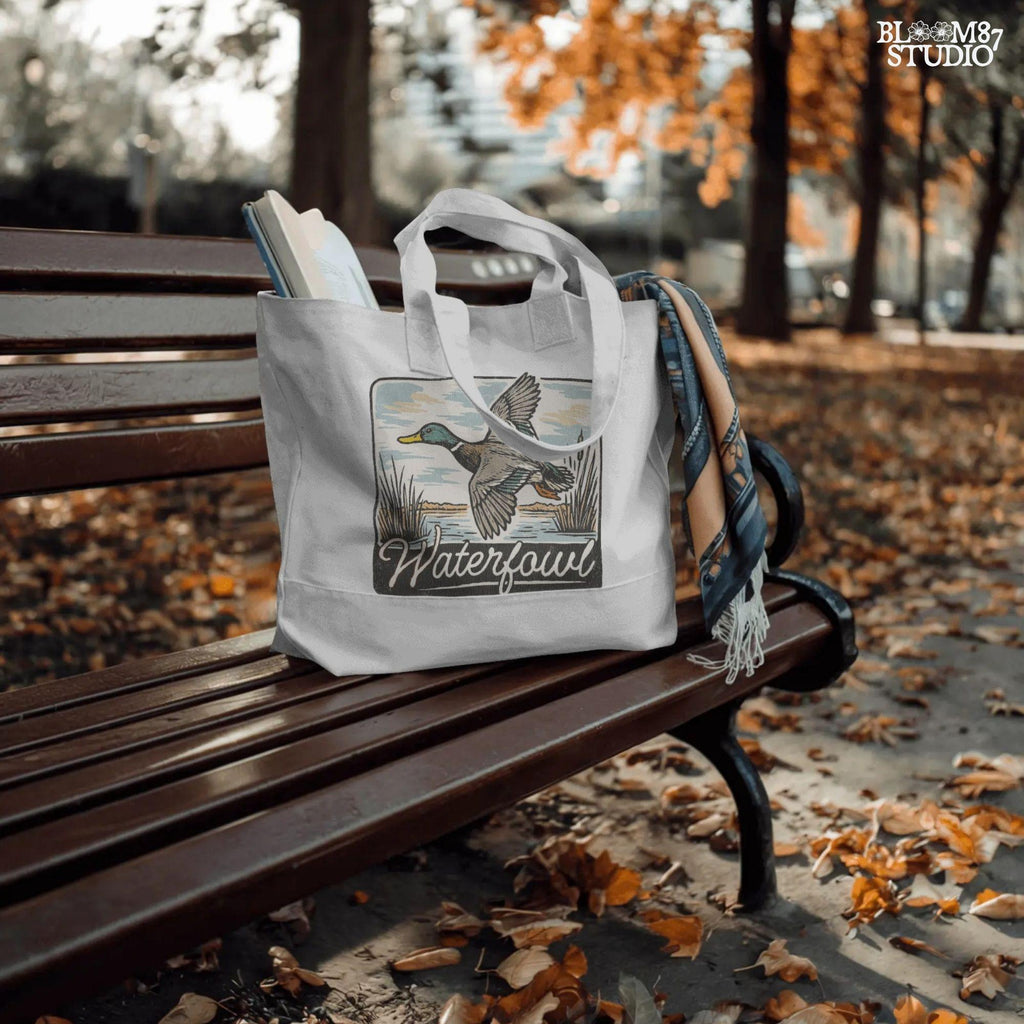 Vintage-style illustration of a flying mallard duck over a marsh with the word “Waterfowl” in script, perfect for duck hunting and outdoor-themed designs.