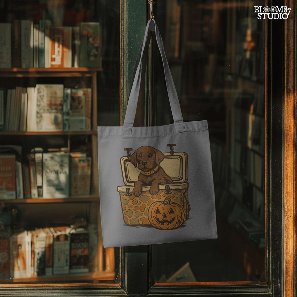 Cute brown hunting dog in a camo cooler next to a carved pumpkin, Halloween-themed sublimation PNG for fall shirts or seasonal crafts.