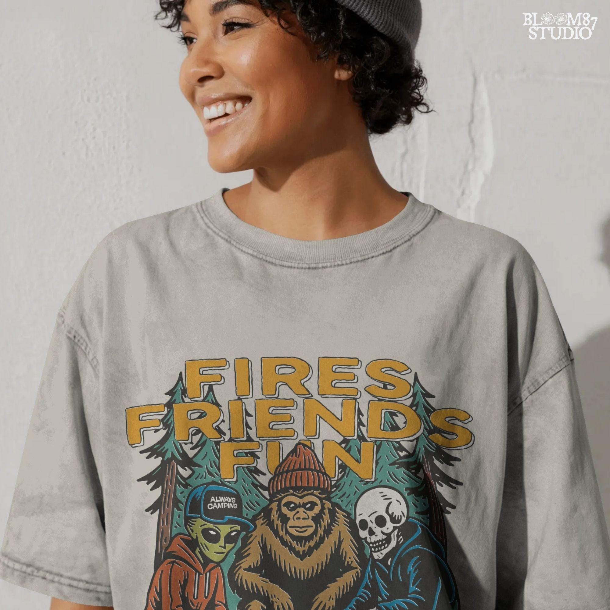 Funny cartoon-style illustration of an alien, bigfoot, and skeleton sitting around a campfire with the text “Fires. Friends. Fun. Camping Crew,” ideal for camping humor designs.