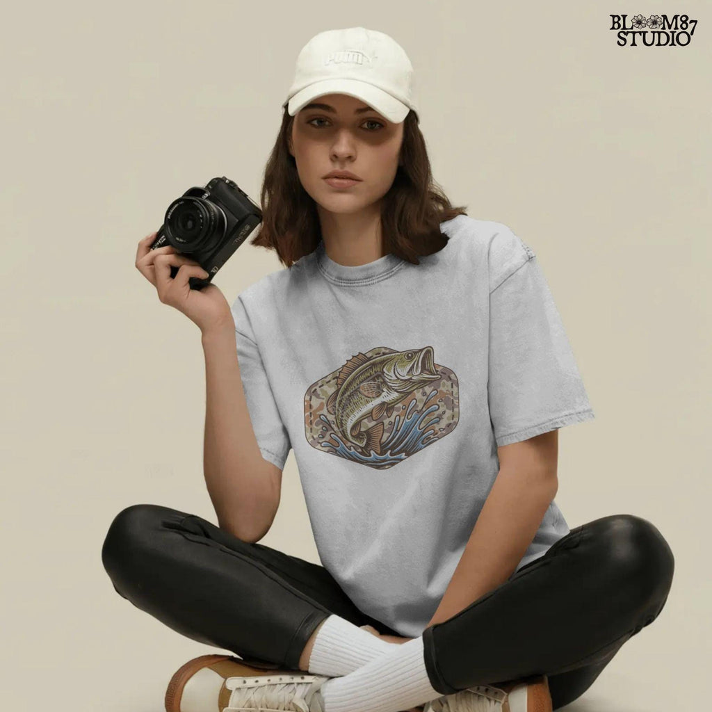 Illustration of a largemouth bass jumping from water with a camo background, designed for fishing-themed sublimation and outdoorsman shirt printing.