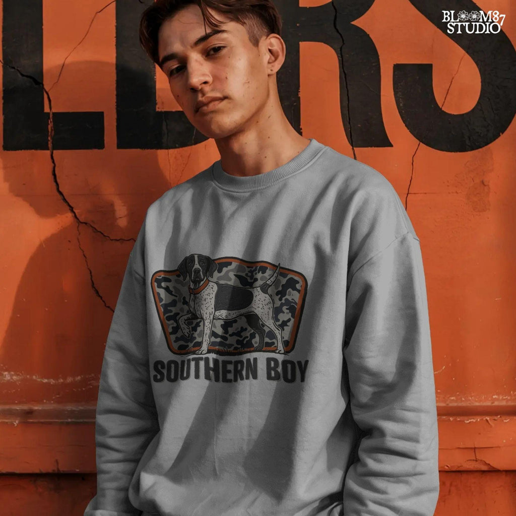 Illustration of a black and white pointer hunting dog standing in front of a gray camo background with the words “Southern Boy” beneath in bold rustic font.