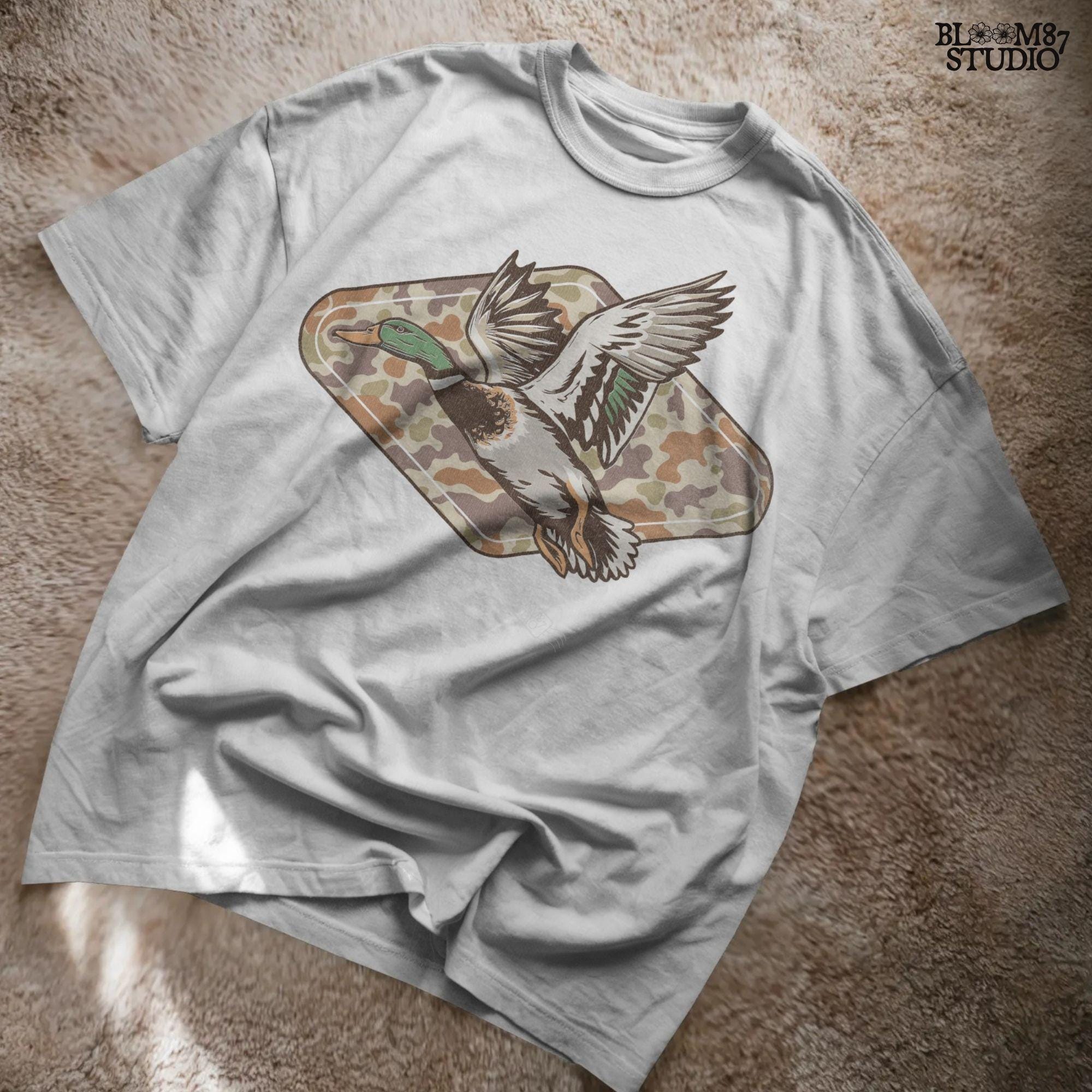 Mallard duck flying over a tan and brown woodland camo background, stylized for fall hunting and Thanksgiving sublimation projects.