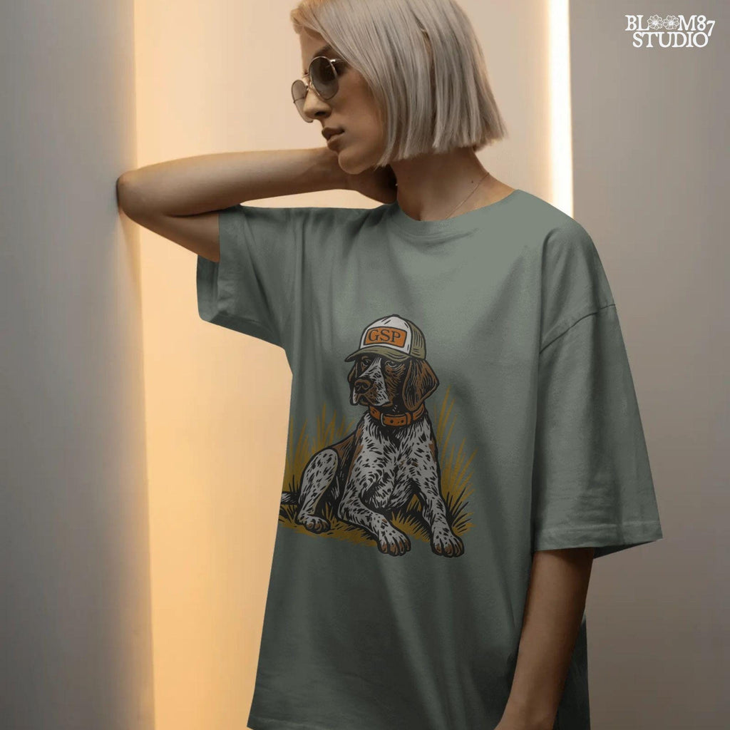 Illustration of a German Shorthaired Pointer dog wearing a GSP hat and orange collar, sitting in golden grass, perfect for hunting or fall-themed sublimation.