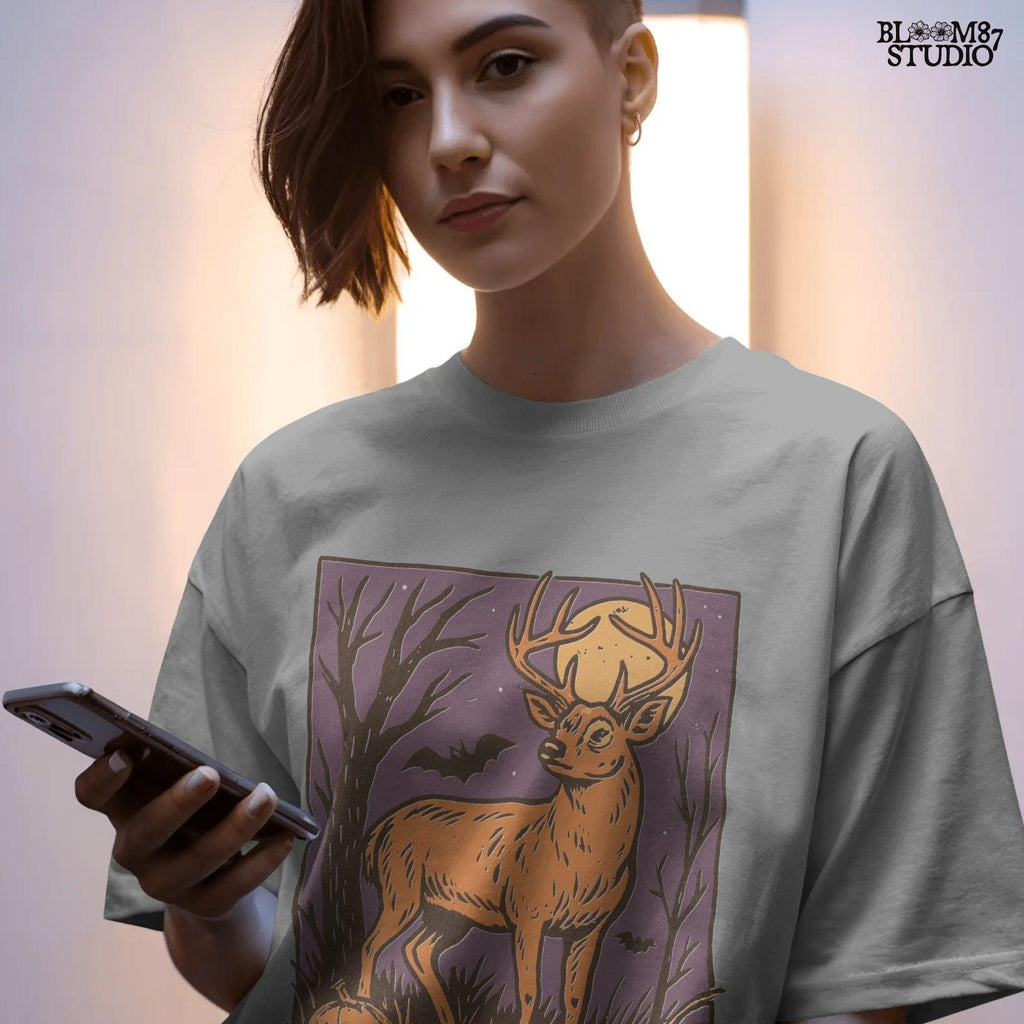 Halloween PNG design of a deer buck under full moon with jack-o’-lantern, bats, and spooky forest background in fall colors