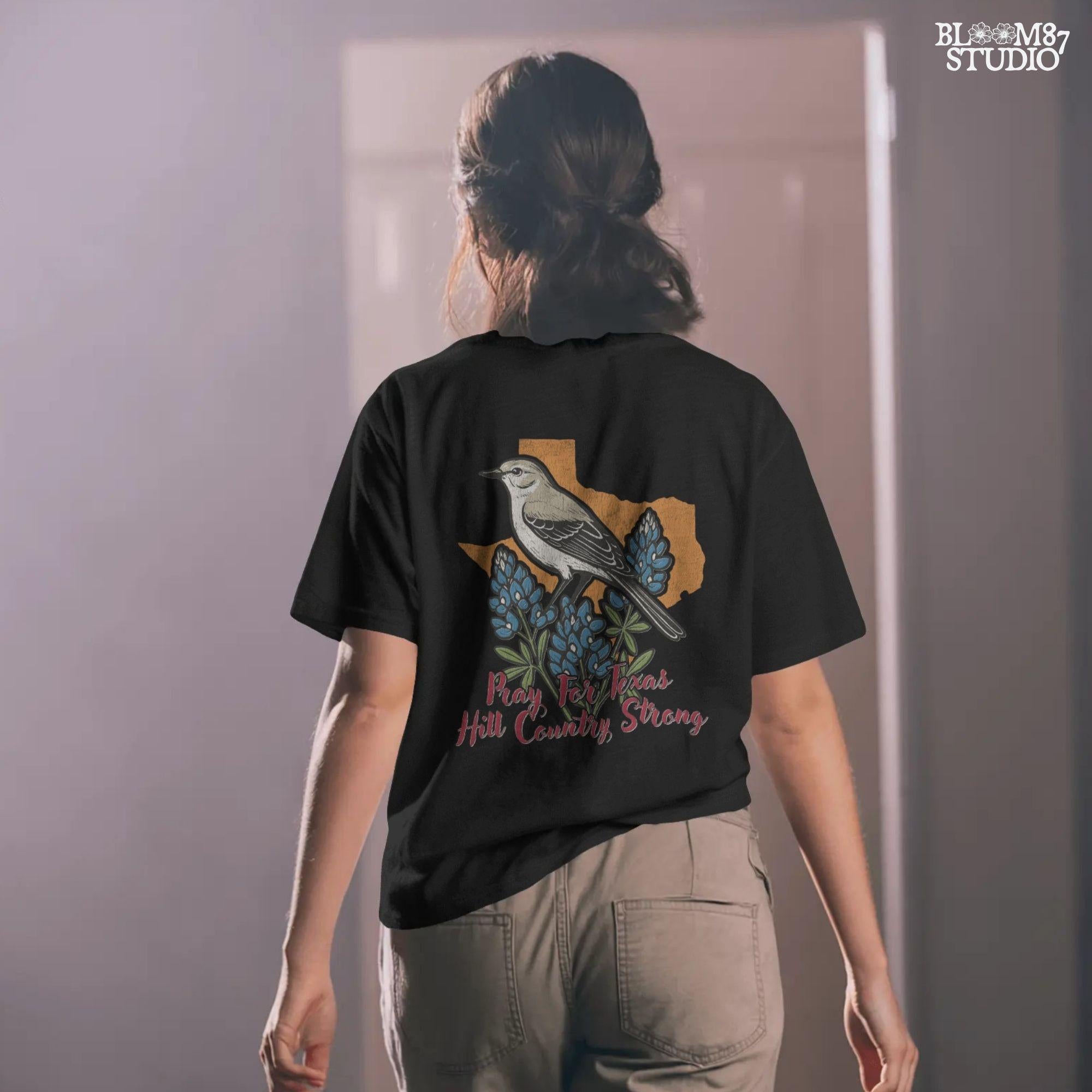 Illustration of a mockingbird on bluebonnets in front of Texas state outline with text “Pray for Texas Hill Country Strong,” designed for sublimation and awareness.