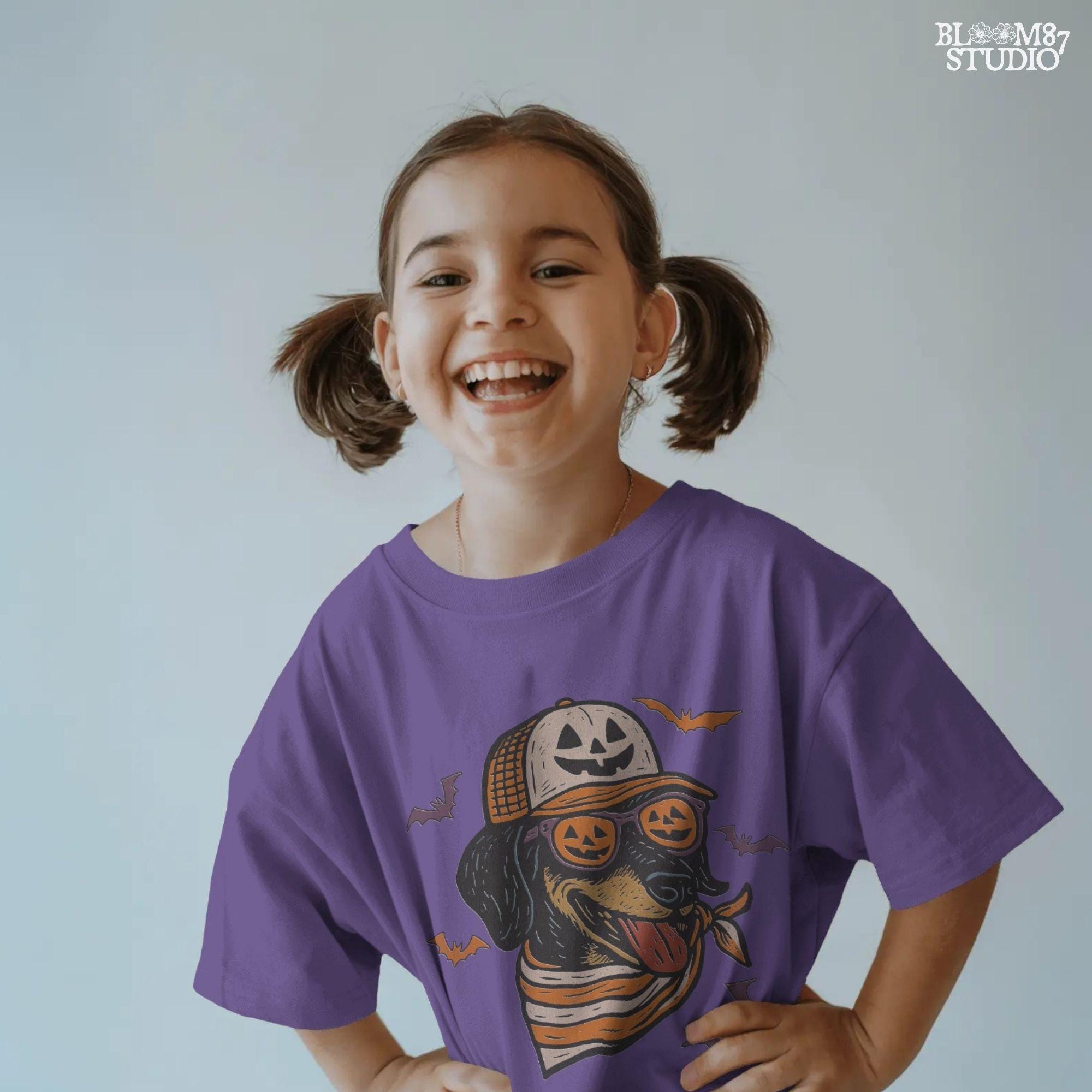 Halloween dachshund wearing pumpkin sunglasses, jack-o’-lantern hat, and orange bandana with flying bats, sublimation PNG design