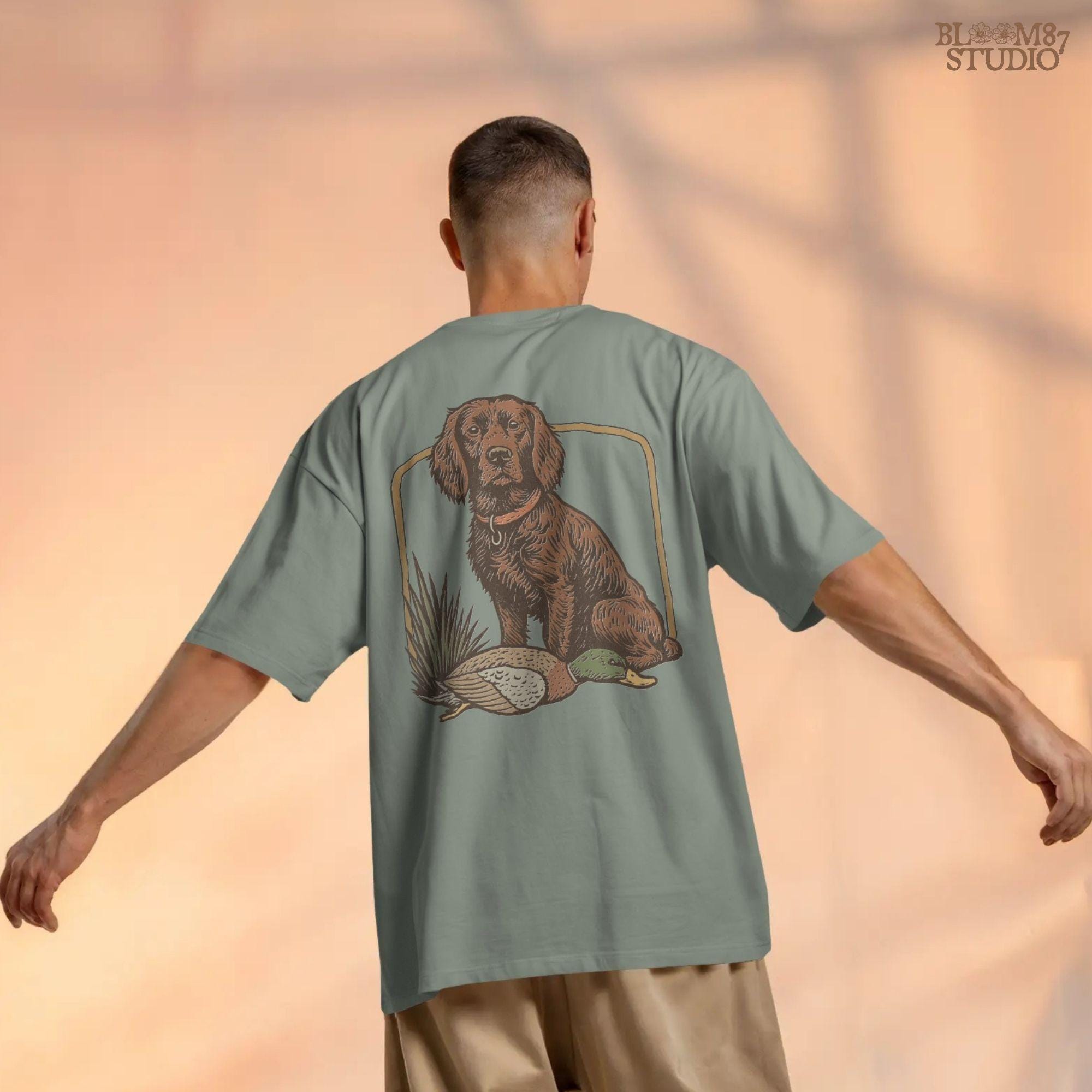 Vintage-style PNG of a Boykin Spaniel dog sitting with a harvested mallard duck, perfect for fall hunting sublimation and Southern dog lovers