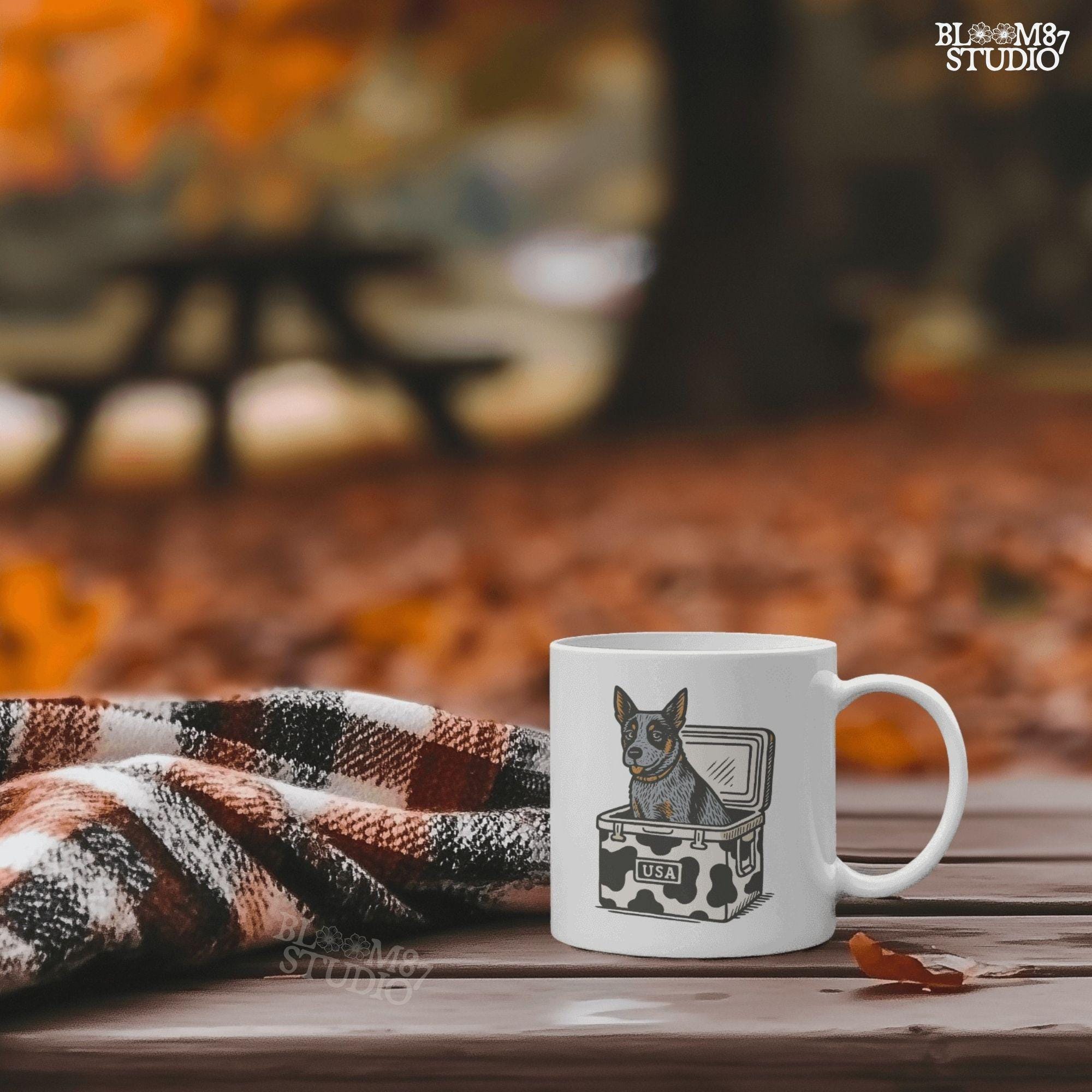 Cartoon-style Blue Heeler dog sitting inside a cowprint cooler with USA patch, perfect for southern patriotic summer sublimation design.