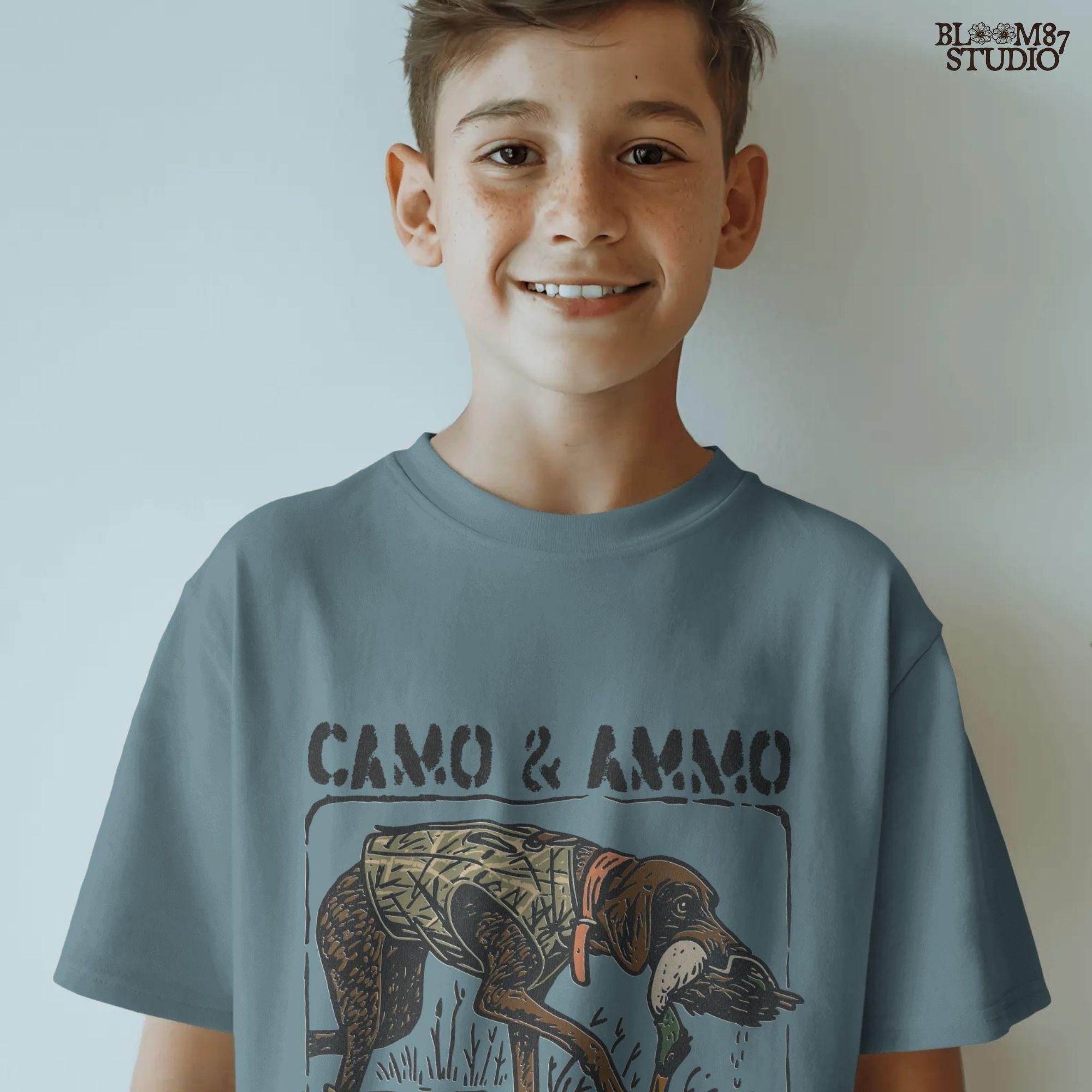 Hunting dog in a camo vest retrieving a mallard duck with a swimming duck nearby and text saying “Camo & Ammo and a Good Duck Dog”.