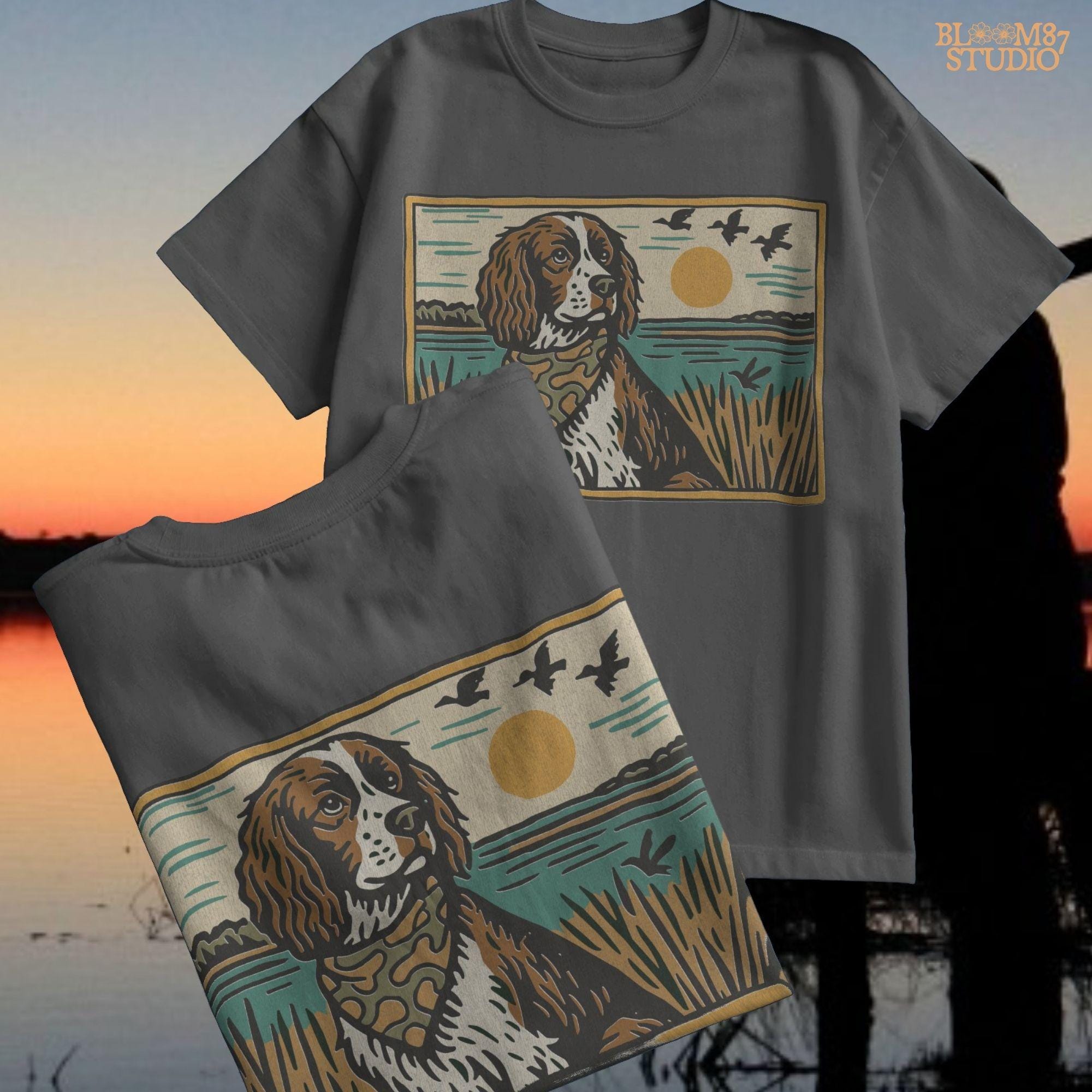 Illustration of a spaniel dog in a camouflage bandana sitting near a lake with sunset and ducks flying overhead; rustic southern sublimation PNG for apparel.