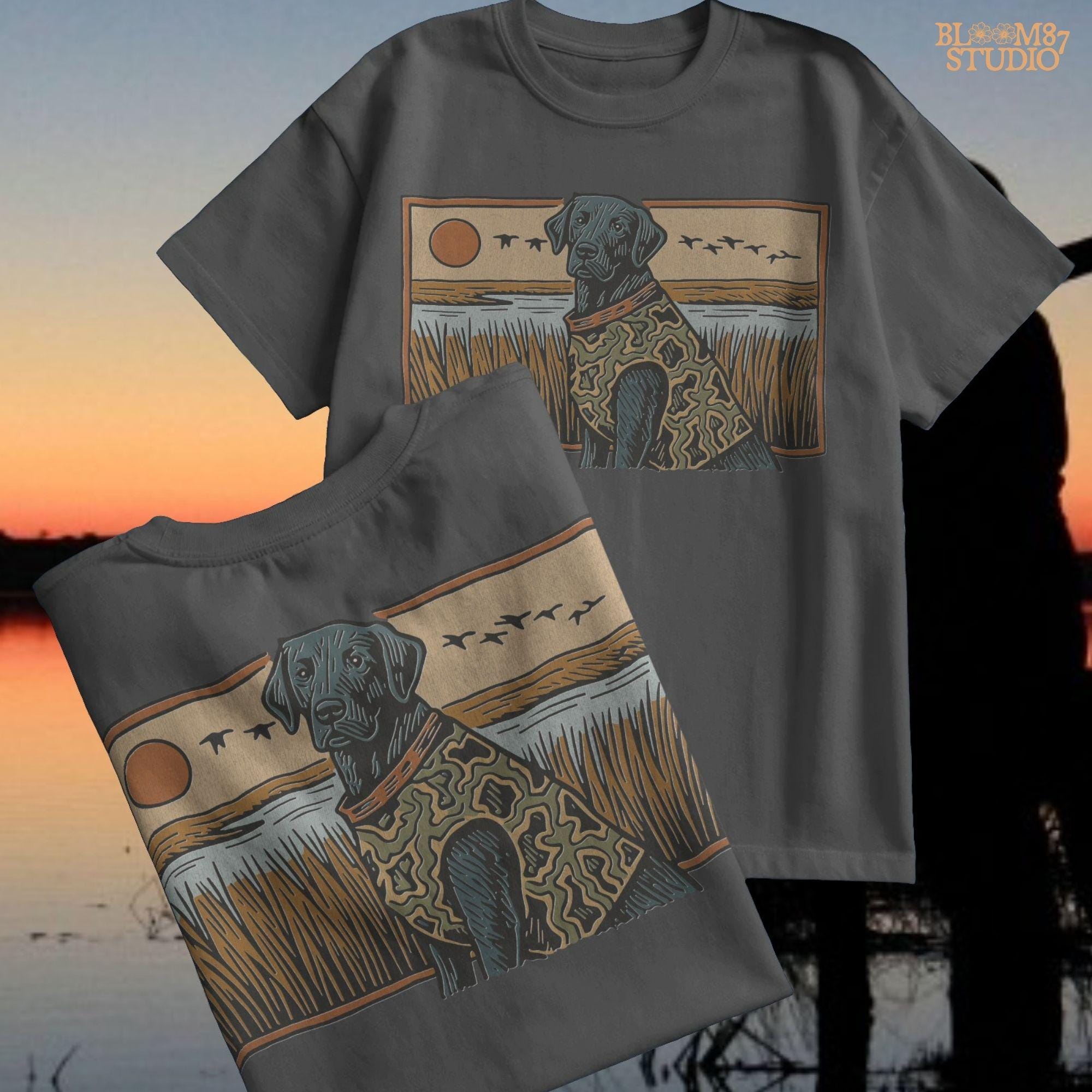 Camo-clad black Labrador retriever sitting in a grassy marsh with flying ducks and a sunset background, digital PNG for hunting dog sublimation designs.