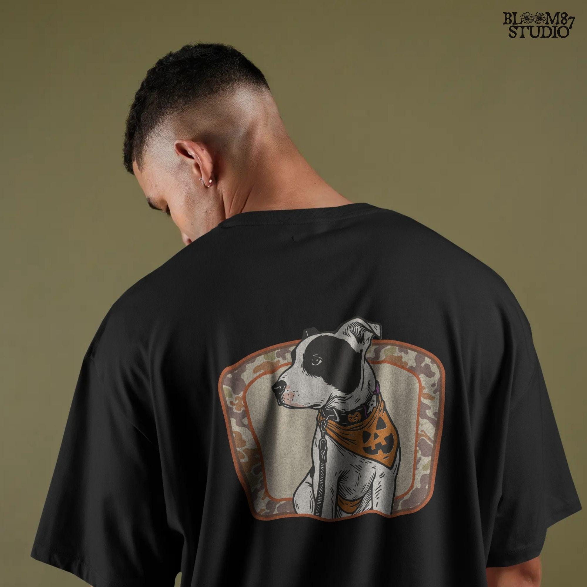 Illustration of a black and white pitbull wearing a jack-o’-lantern bandana and Halloween collar, framed by a camo background.