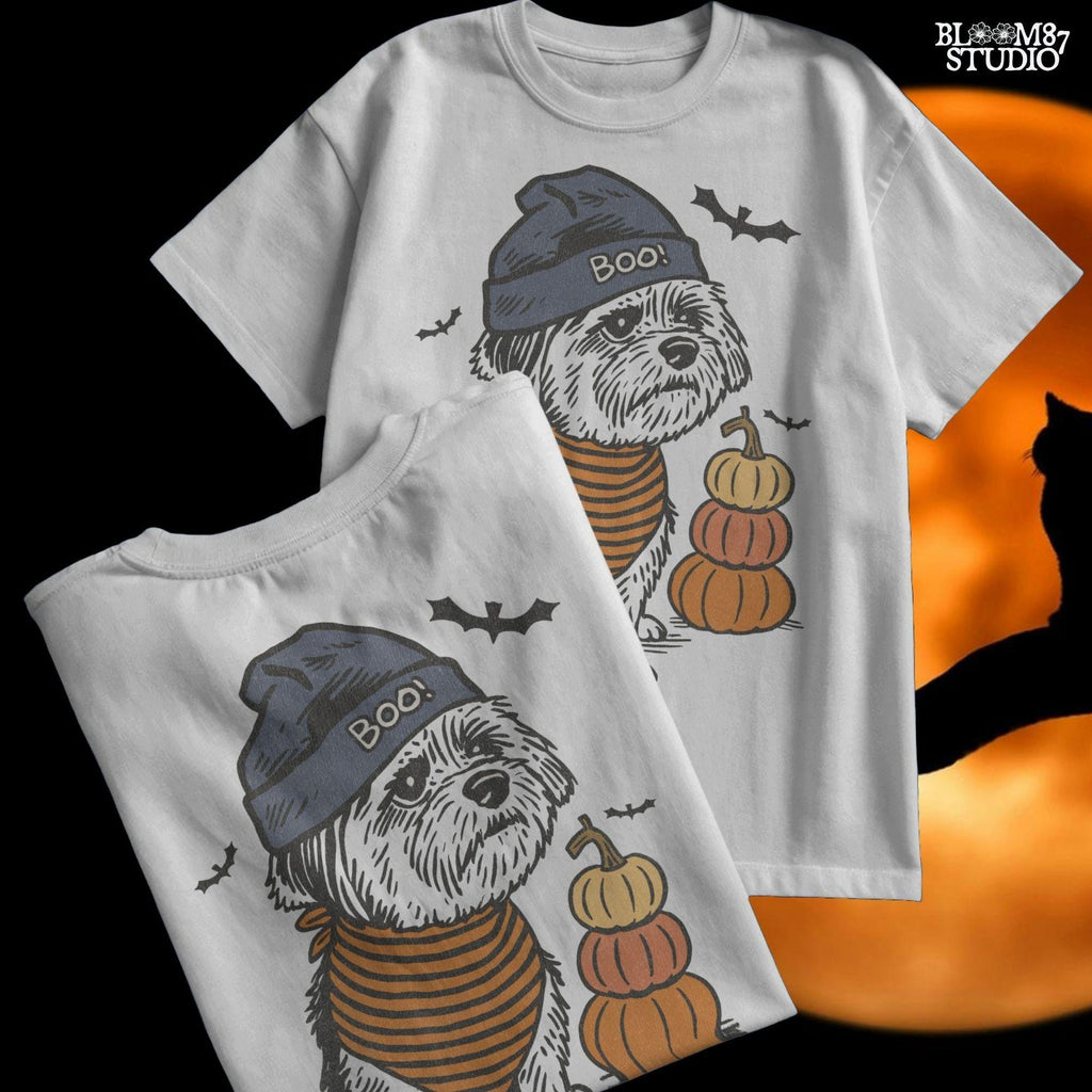 Illustration of a black dog wearing a “BOO!” hat and orange striped bandana, sitting next to stacked pumpkins on a Halloween background.