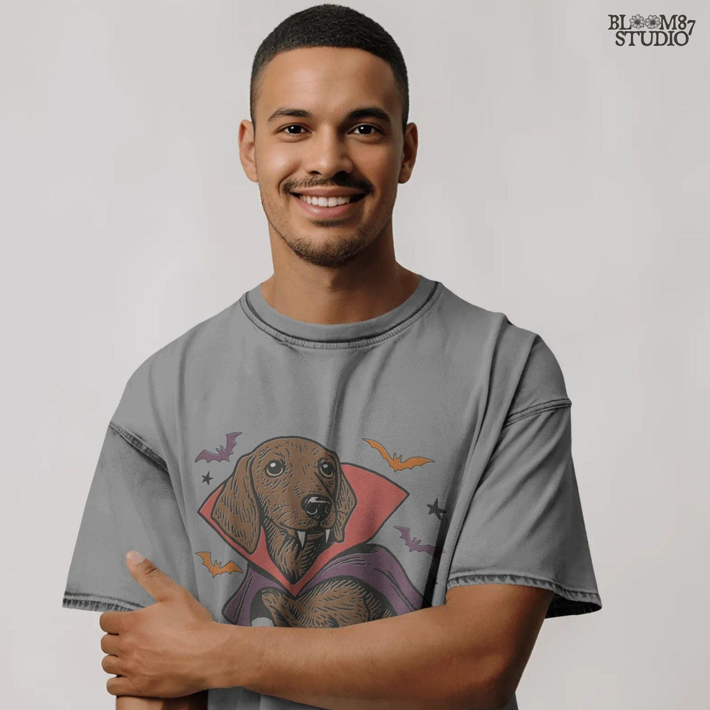 Cute dachshund dressed as a Halloween vampire with red and purple cape, fangs, and surrounded by bats on transparent background.