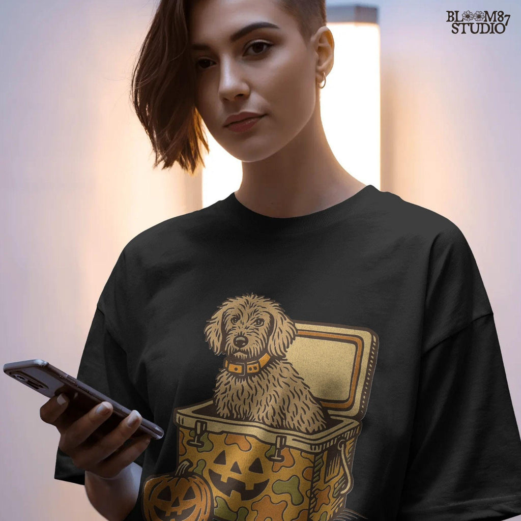 Cute golden doodle dog sitting in a Halloween camo cooler with jack-o’-lantern face, fall-themed sublimation graphic on transparent background.