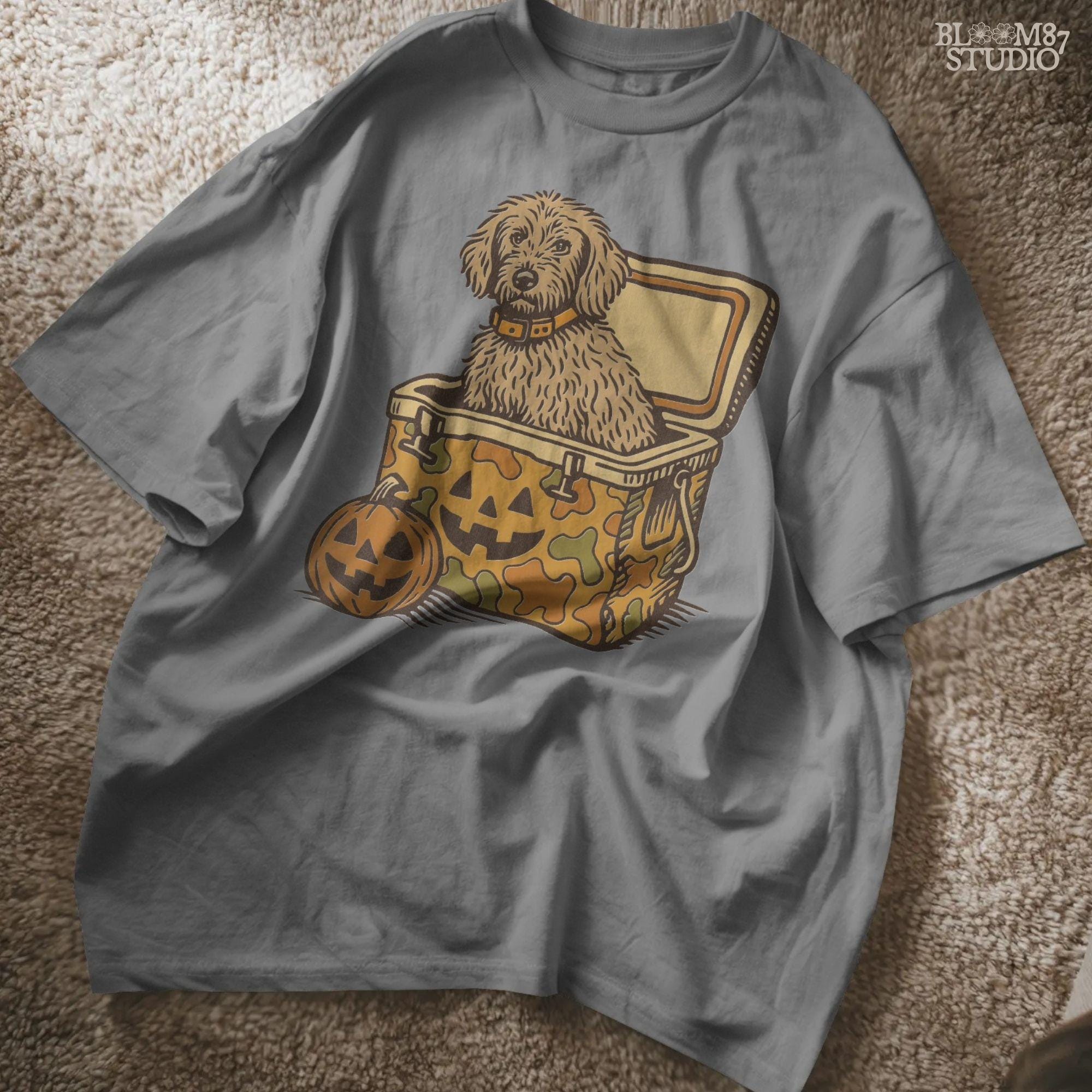 Cute golden doodle dog sitting in a Halloween camo cooler with jack-o’-lantern face, fall-themed sublimation graphic on transparent background.