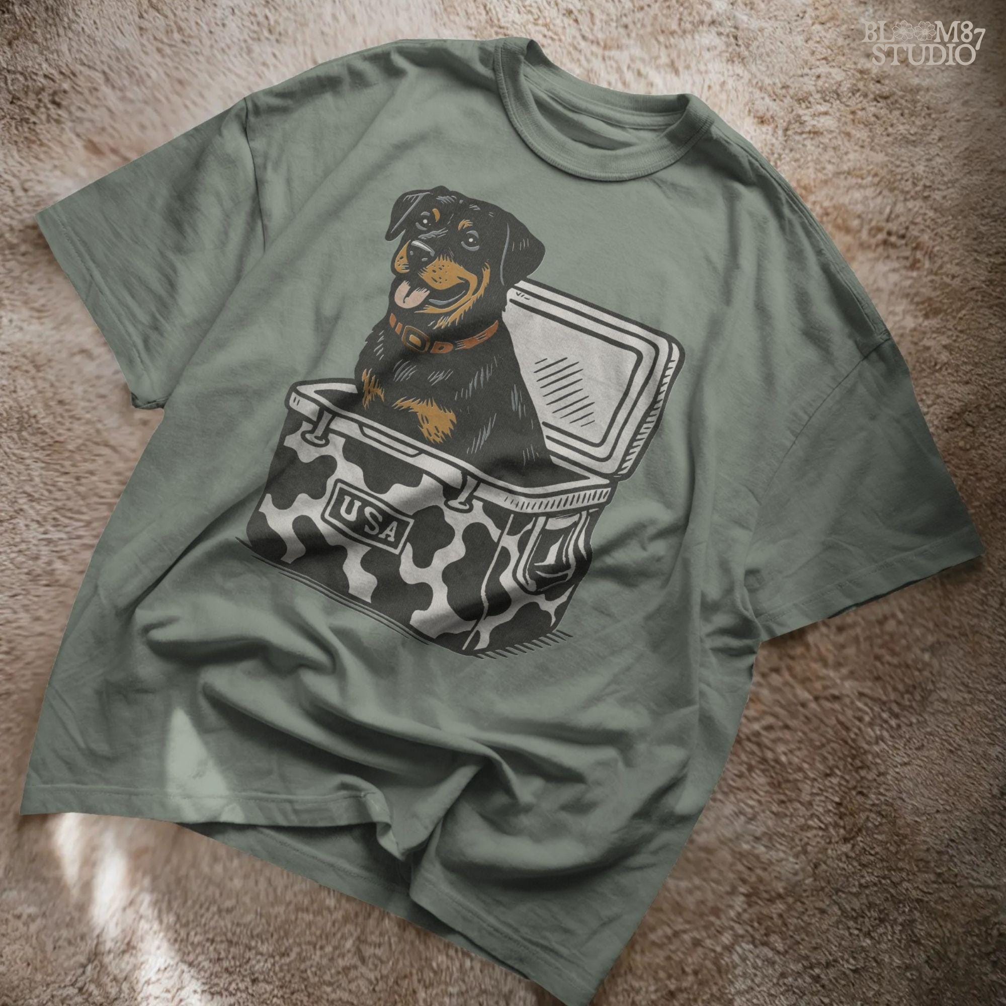 Rottweiler dog sitting in a cow-print USA cooler, smiling with tongue out. Patriotic and humorous sublimation PNG design.