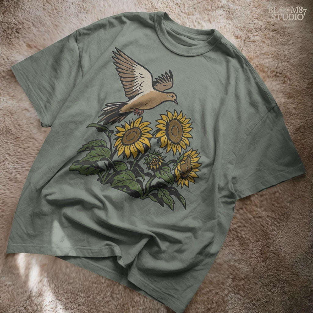 Mourning dove flying above blooming sunflowers with green leaves. Rustic sublimation PNG design for fall and country-themed crafts.Mourning dove flying above blooming sunflowers with green leaves. Rustic sublimation PNG design for fall and country-themed crafts.