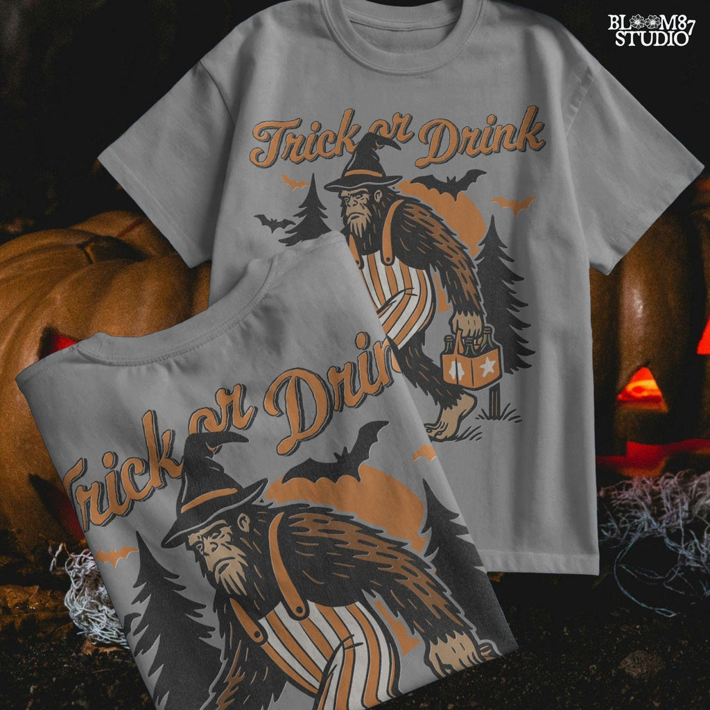 Funny Halloween bigfoot holding beer in witch hat and striped overalls, walking past pumpkins and trees with “Trick or Drink” text above.