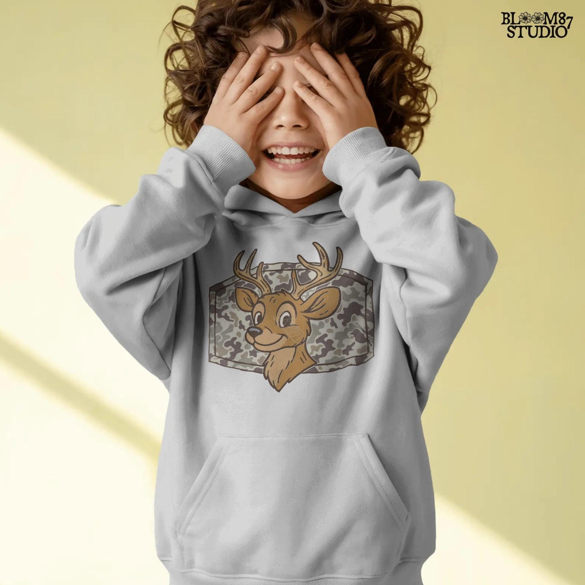 Cartoon deer with big antlers in front of a camouflage background – sublimation PNG design for fall, back to school, or kids’ hunting season shirts.