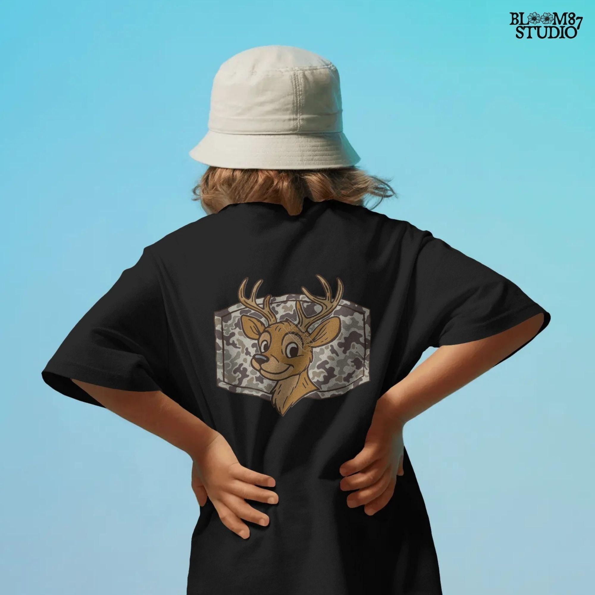 Cartoon deer with big antlers in front of a camouflage background – sublimation PNG design for fall, back to school, or kids’ hunting season shirts.