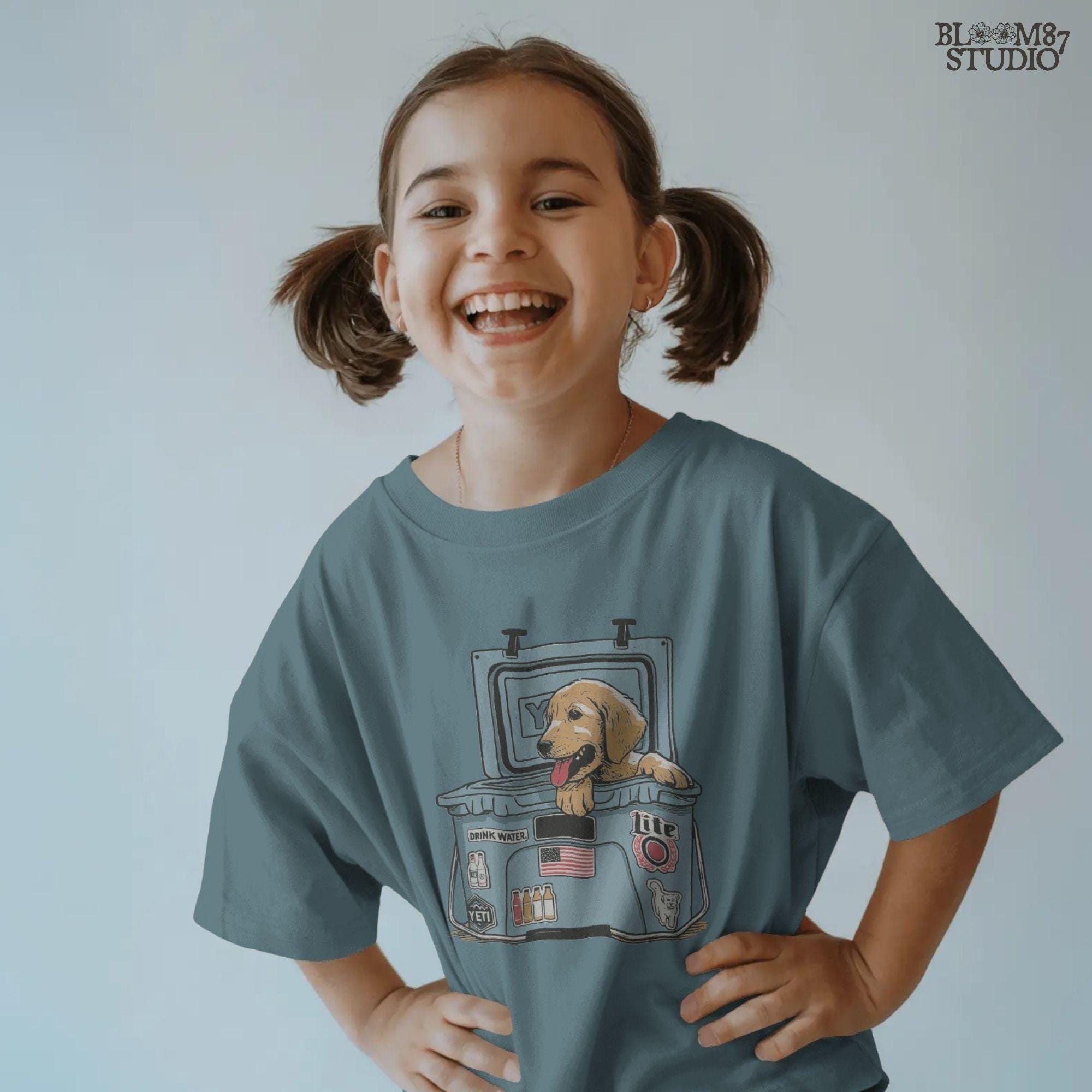 Illustration of a golden retriever puppy sitting inside a YETI cooler covered in stickers, designed for sublimation and lake life dog dad gifts.