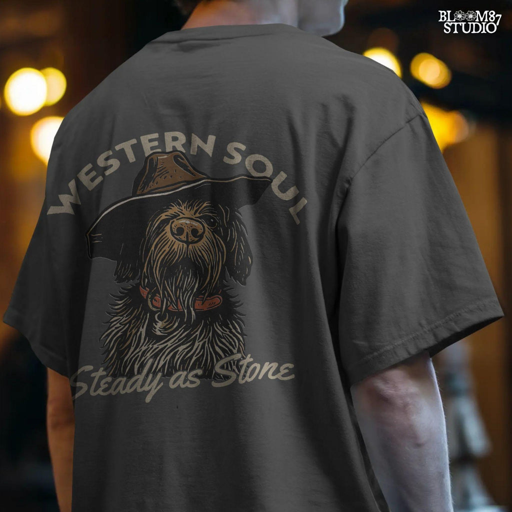 Rustic hunting dog with long fur and cowboy hat, labeled “Western Soul – Steady as Stone,” styled for western-themed sublimation and apparel use