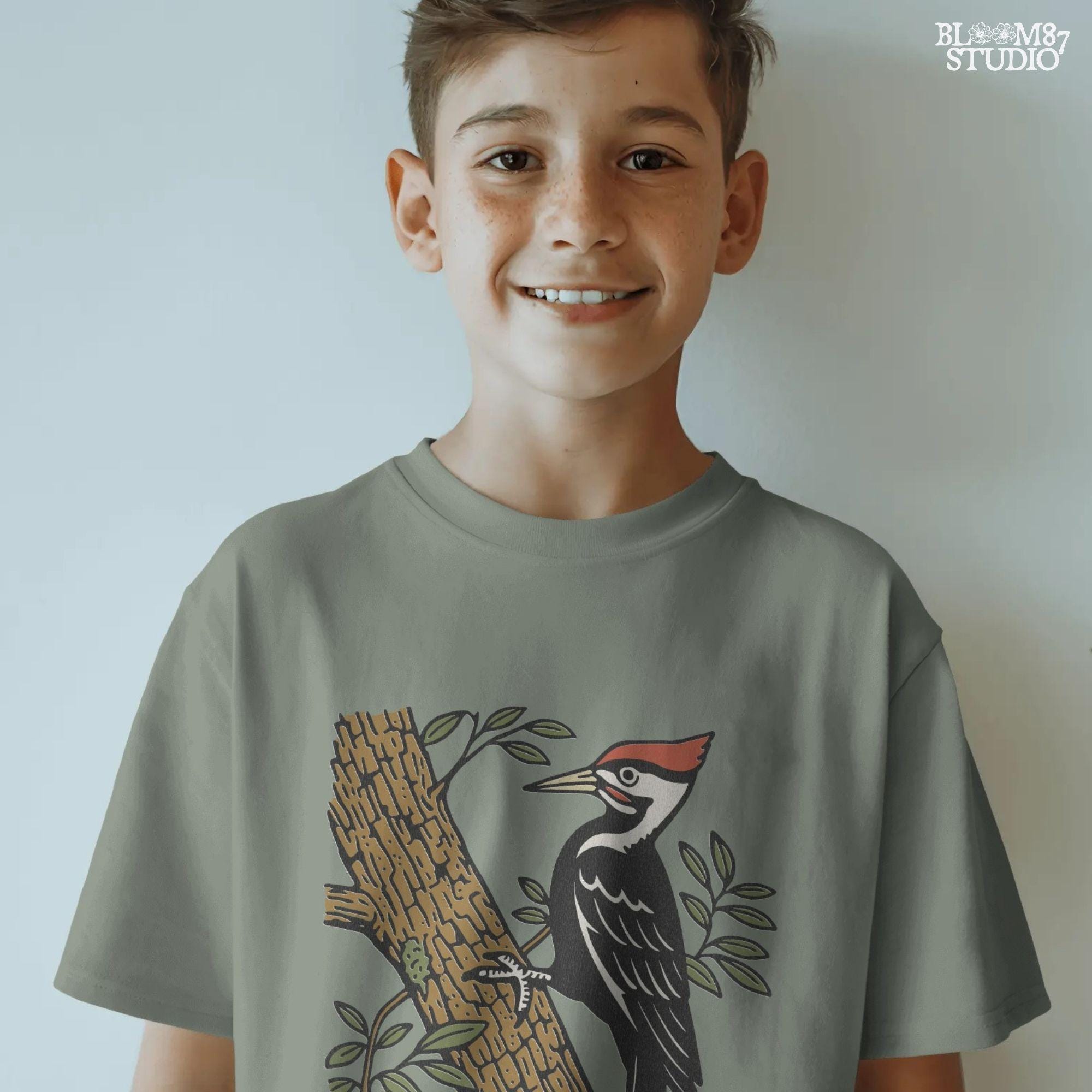 Vintage woodpecker perched on a tree trunk with green leaves and the word “Woodland” in rustic script, fall-themed forest sublimation PNG.