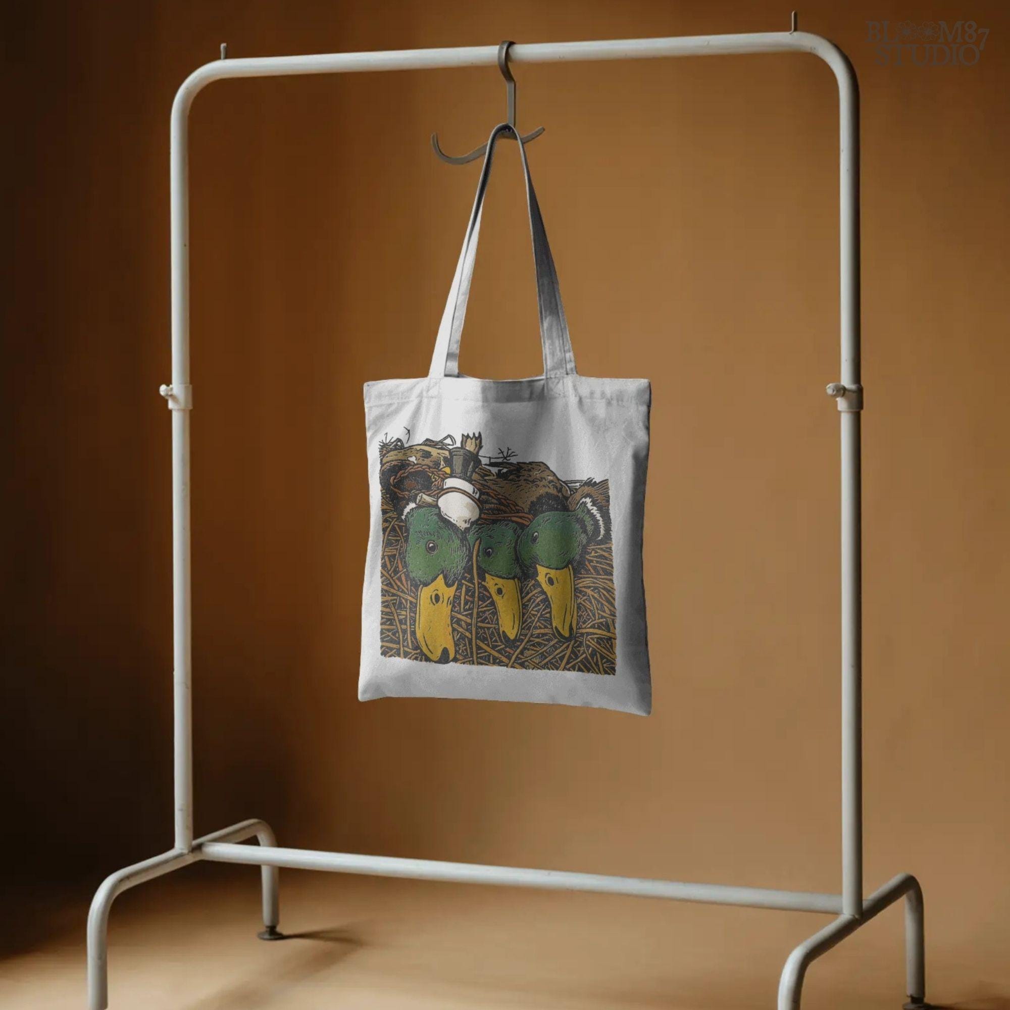 Illustration of three drake mallard ducks with green heads and yellow bills, lying in marsh grass with a duck call, hunting PNG sublimation design