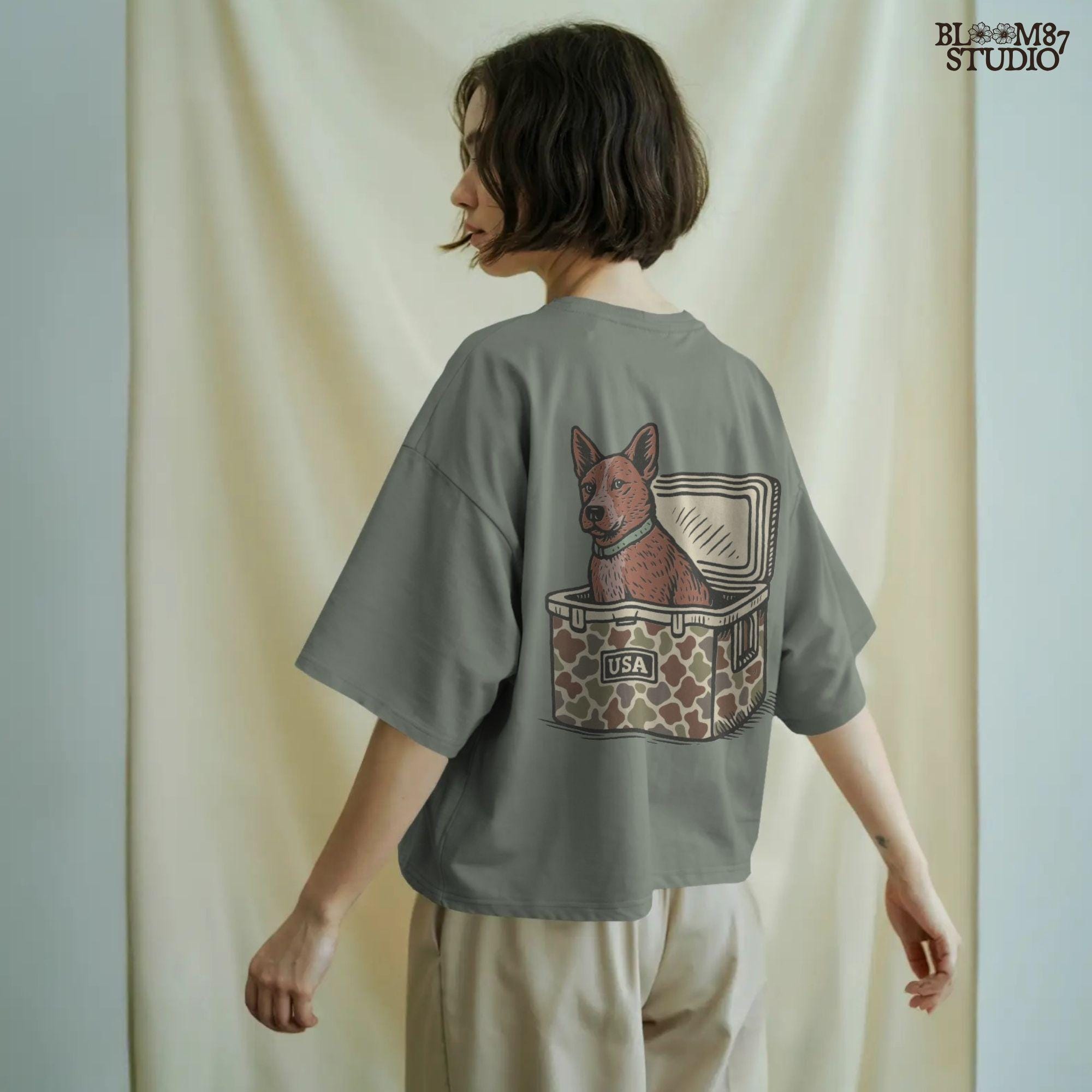 Illustration of an Australian Cattle Dog (Blue Heeler) sitting inside a camouflage cooler with “USA” label, rustic country-style sublimation PNG design