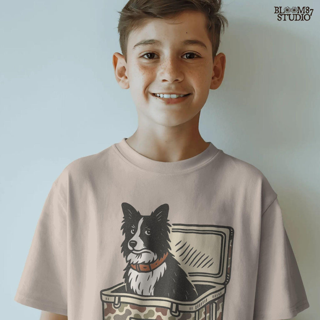 Illustration of a Border Collie sitting inside a camouflage cooler labeled “USA,” rustic farm and ranch-themed sublimation PNG design