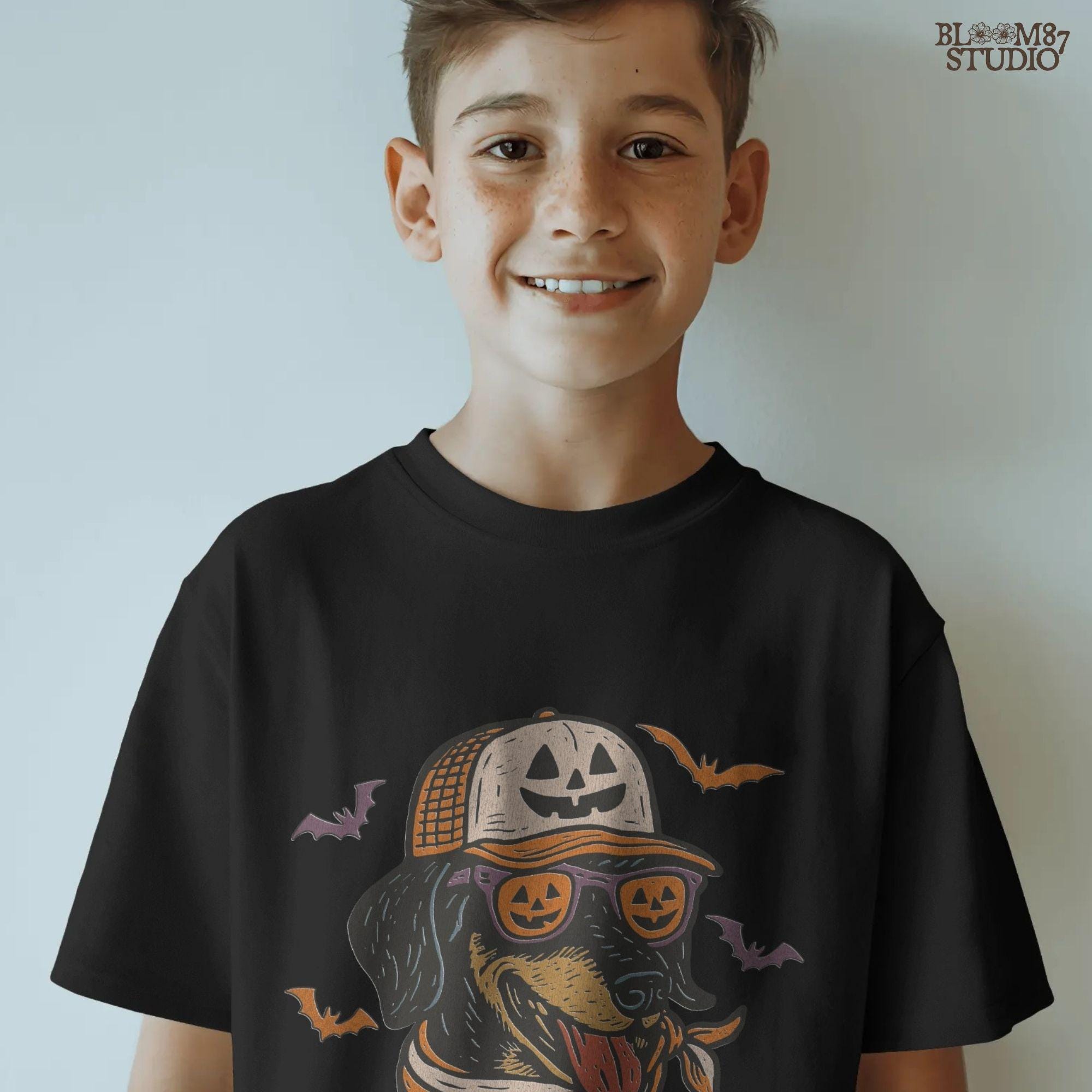 Halloween dachshund wearing pumpkin sunglasses, jack-o’-lantern hat, and orange bandana with flying bats, sublimation PNG design