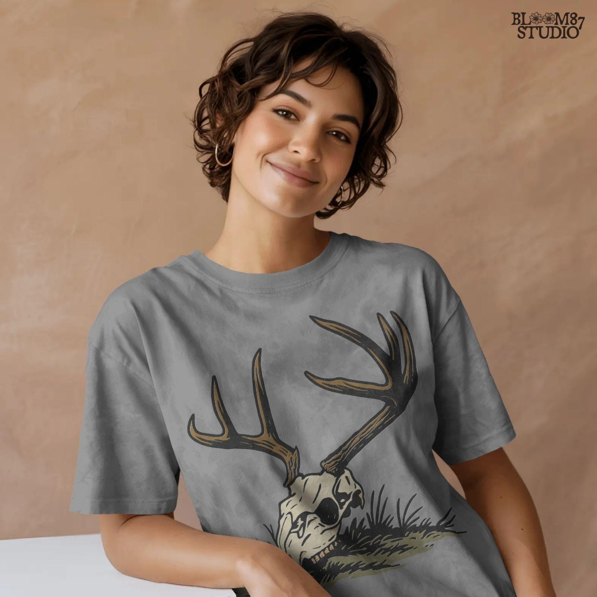 Rustic illustration of a deer skull with large antlers lying on grass, PNG design for hunting-themed and western-style sublimation crafts