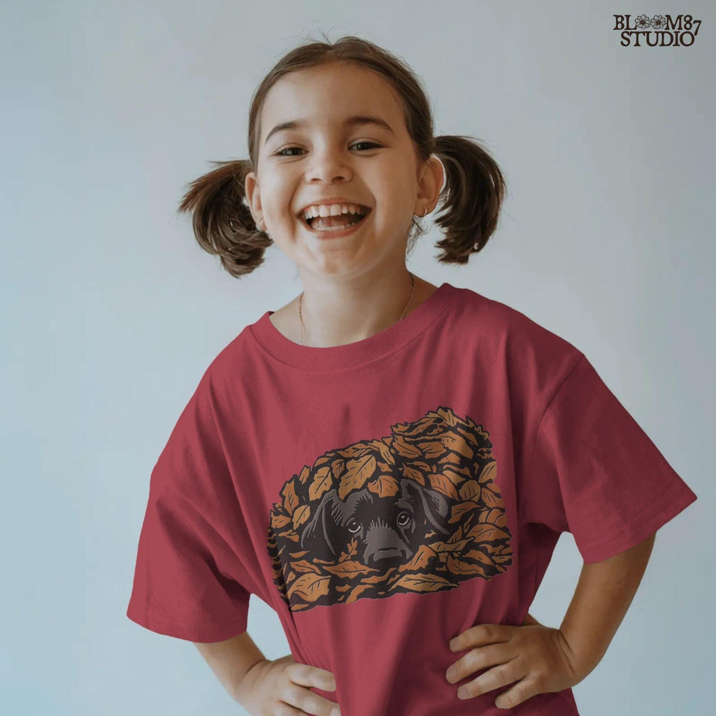 Cute black Labrador retriever peeking through a pile of orange autumn leaves, rustic fall sublimation PNG design