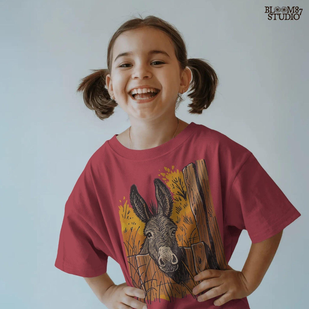 Vintage-style donkey looking through a rustic wooden fence with golden fall foliage in the background, perfect for sublimation crafts