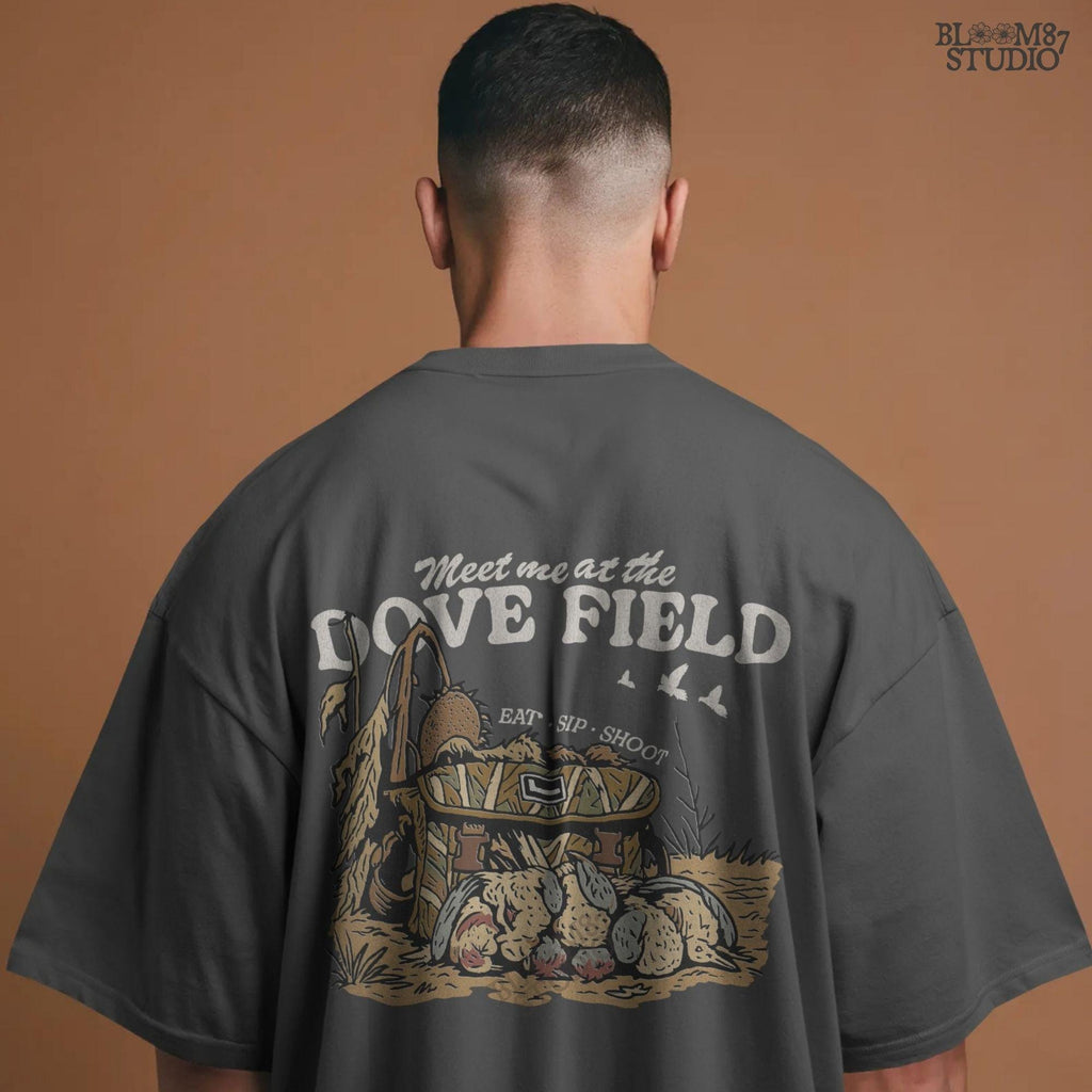 Camo hunting bag in a cornfield surrounded by harvested mourning doves with the phrase “Meet Me at the Dove Field” in vintage lettering.