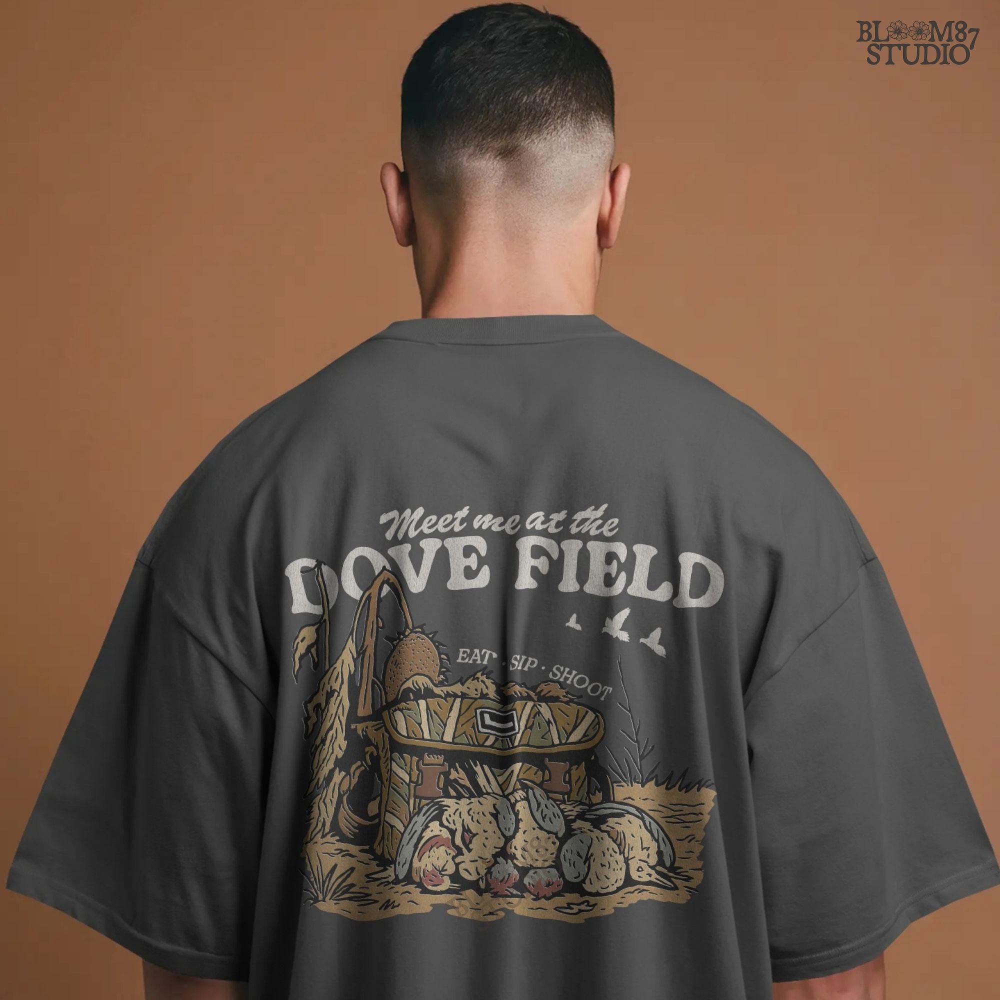 Camo hunting bag in a cornfield surrounded by harvested mourning doves with the phrase “Meet Me at the Dove Field” in vintage lettering.