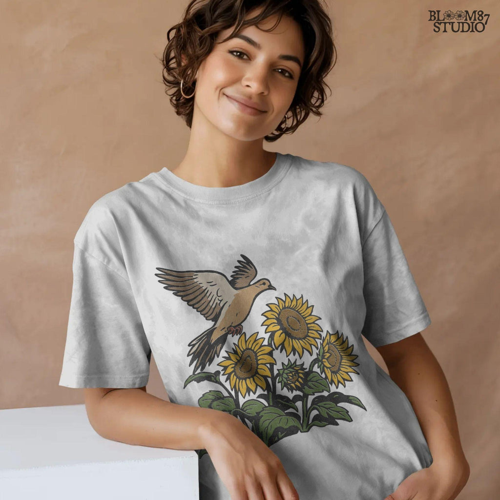 Mourning dove flying above blooming sunflowers with green leaves. Rustic sublimation PNG design for fall and country-themed crafts.