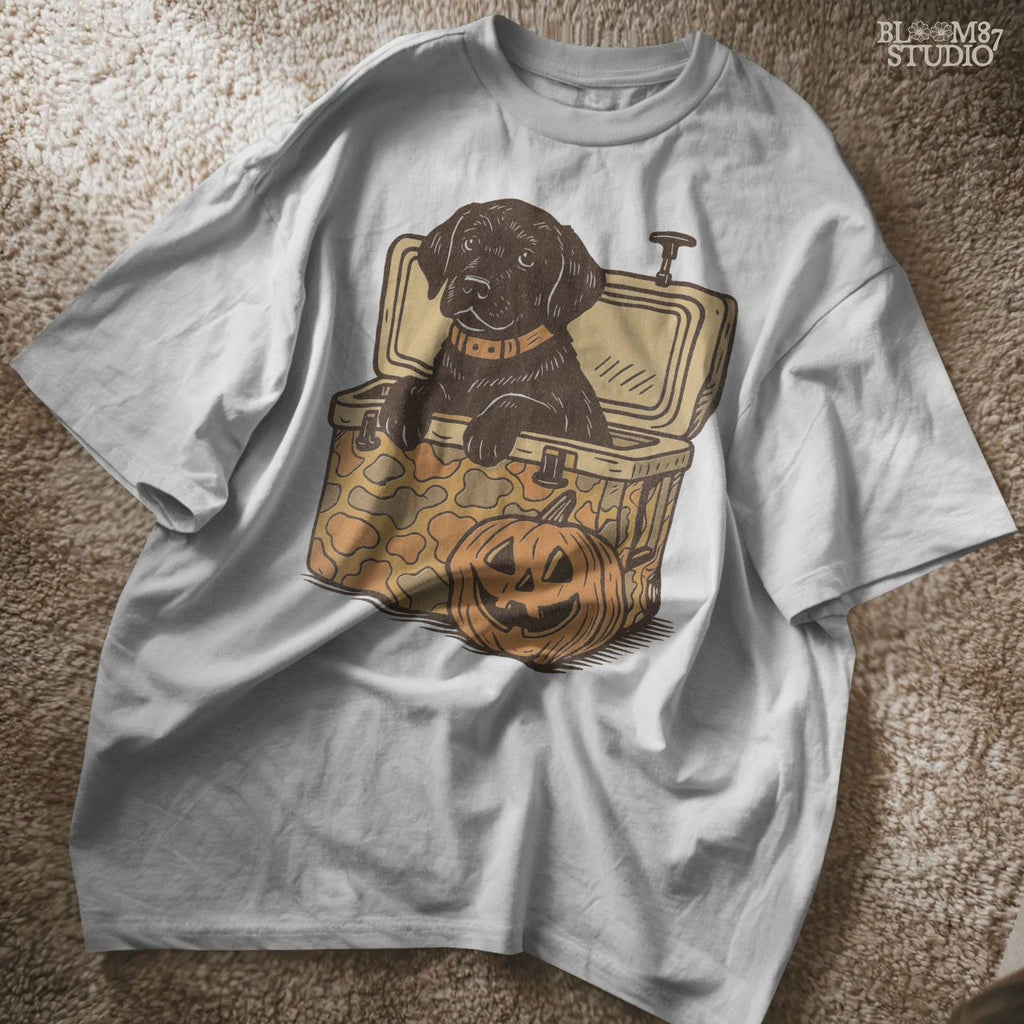 Black Labrador retriever sitting in a cooler with a pumpkin, Halloween sublimation PNG design for dog lovers, seasonal crafts, and apparel.