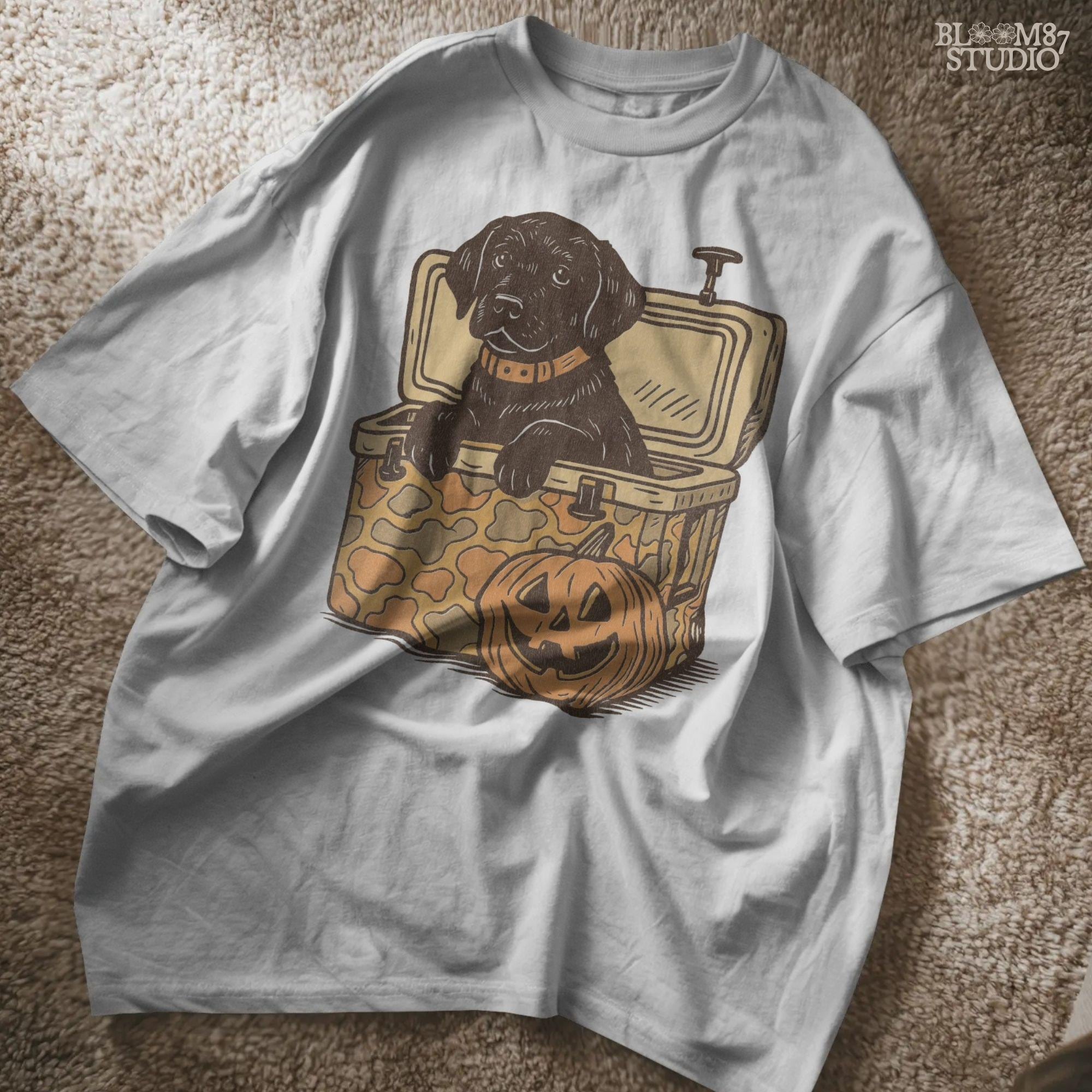 Black Labrador retriever sitting in a cooler with a pumpkin, Halloween sublimation PNG design for dog lovers, seasonal crafts, and apparel.