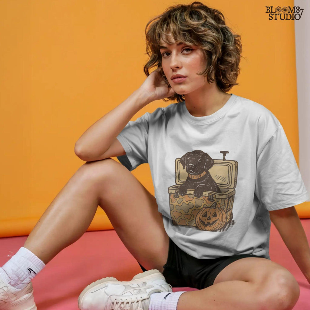 Black Labrador retriever sitting in a cooler with a pumpkin, Halloween sublimation PNG design for dog lovers, seasonal crafts, and apparel.