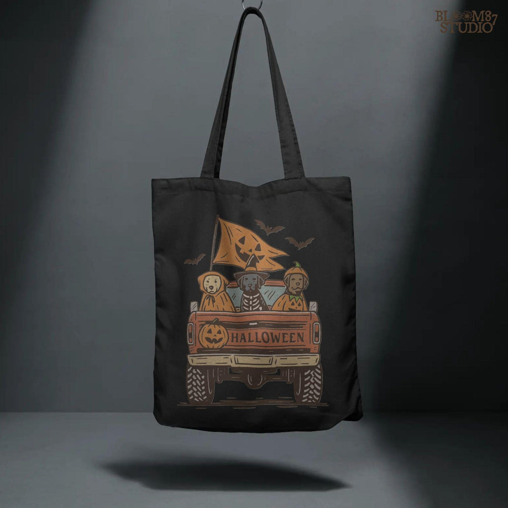 Halloween PNG of three dogs in Halloween costumes riding in a vintage truck with pumpkin flags and bats flying in the background.