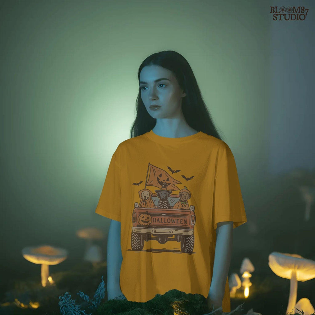 Halloween PNG of three dogs in Halloween costumes riding in a vintage truck with pumpkin flags and bats flying in the background.