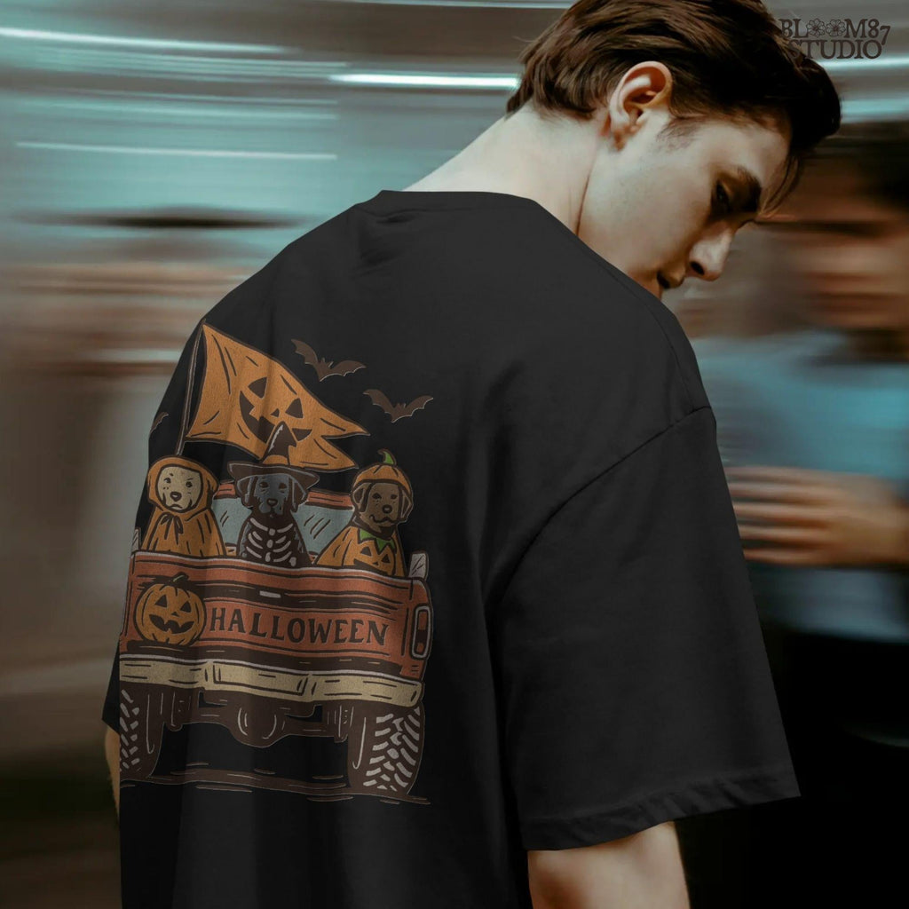 Halloween PNG of three dogs in Halloween costumes riding in a vintage truck with pumpkin flags and bats flying in the background.